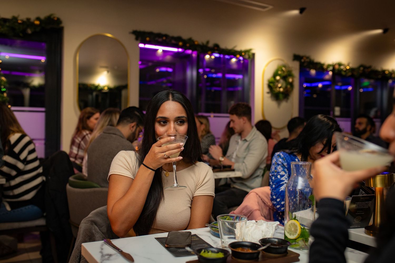 Guest enjoying drinks during restaurant grand opening event with lively atmosphere in Heathrow, London, UK