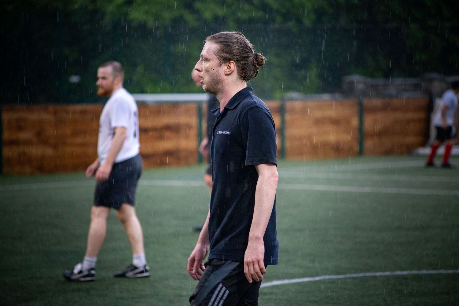 Football player standing on pitch during match with candid sports photography in Central London, UK