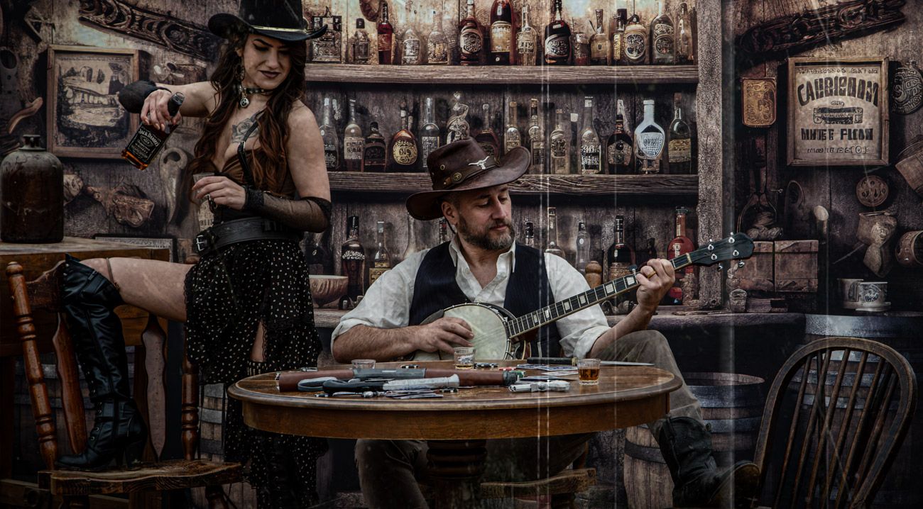 Man playing banjo while woman stands in rustic western saloon bar setting.