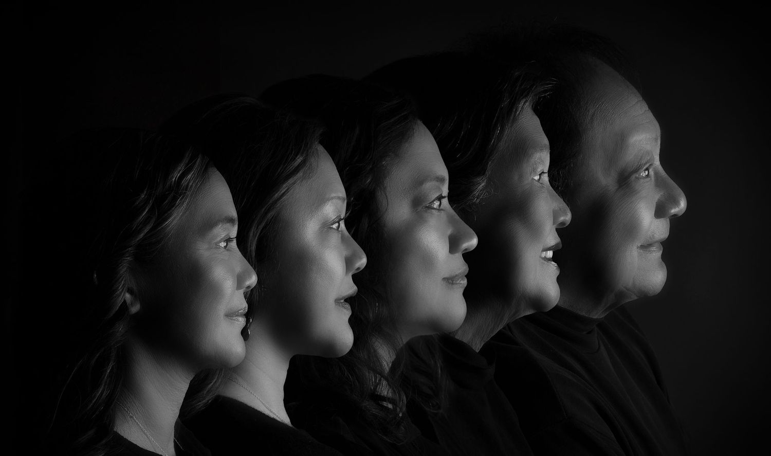 Black and white profile portrait of four women arranged in a row, showing a generational family progression.