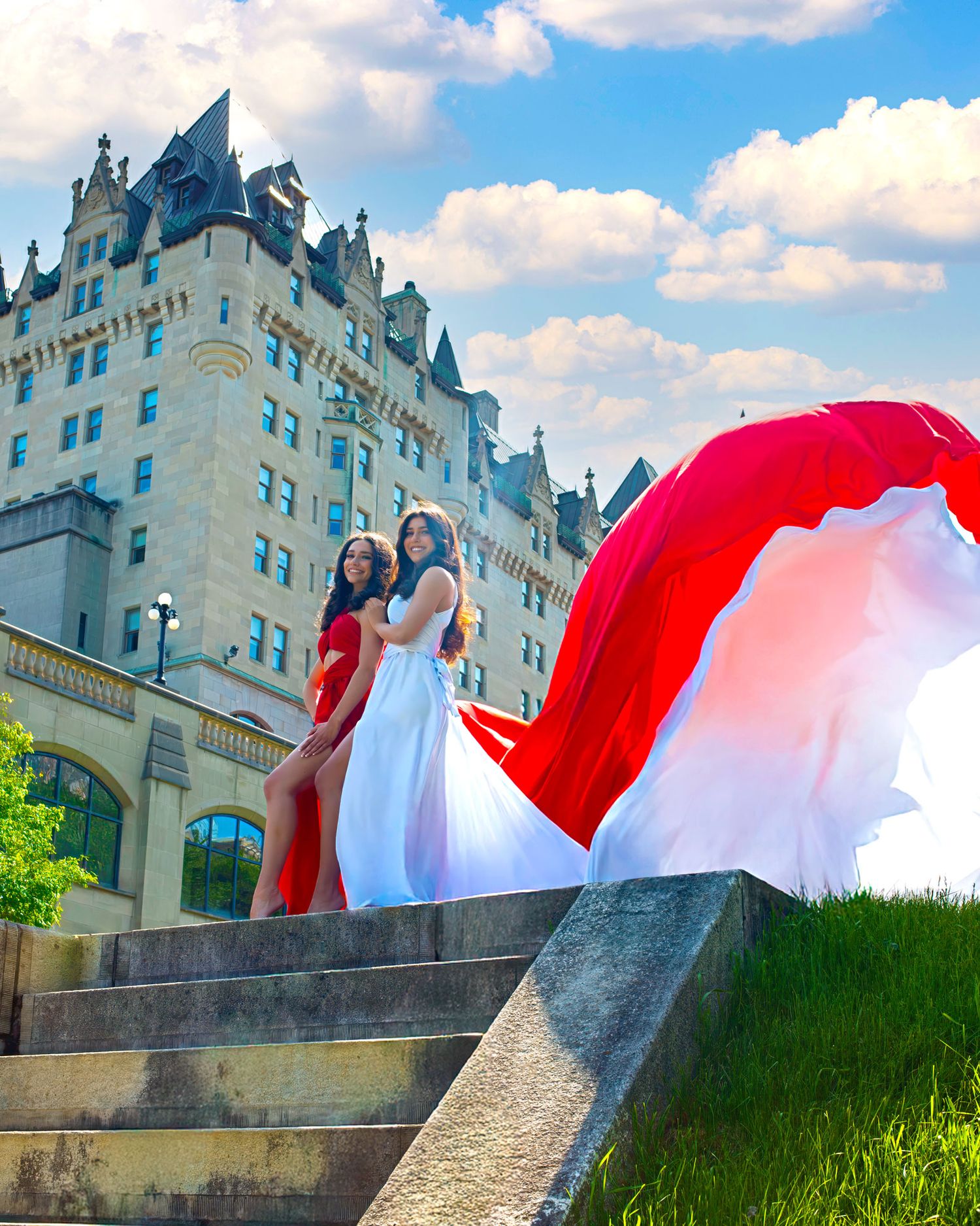 Two women in red and white flying dresses on steps before Château Laurier Ottawa Flying Dress photography
