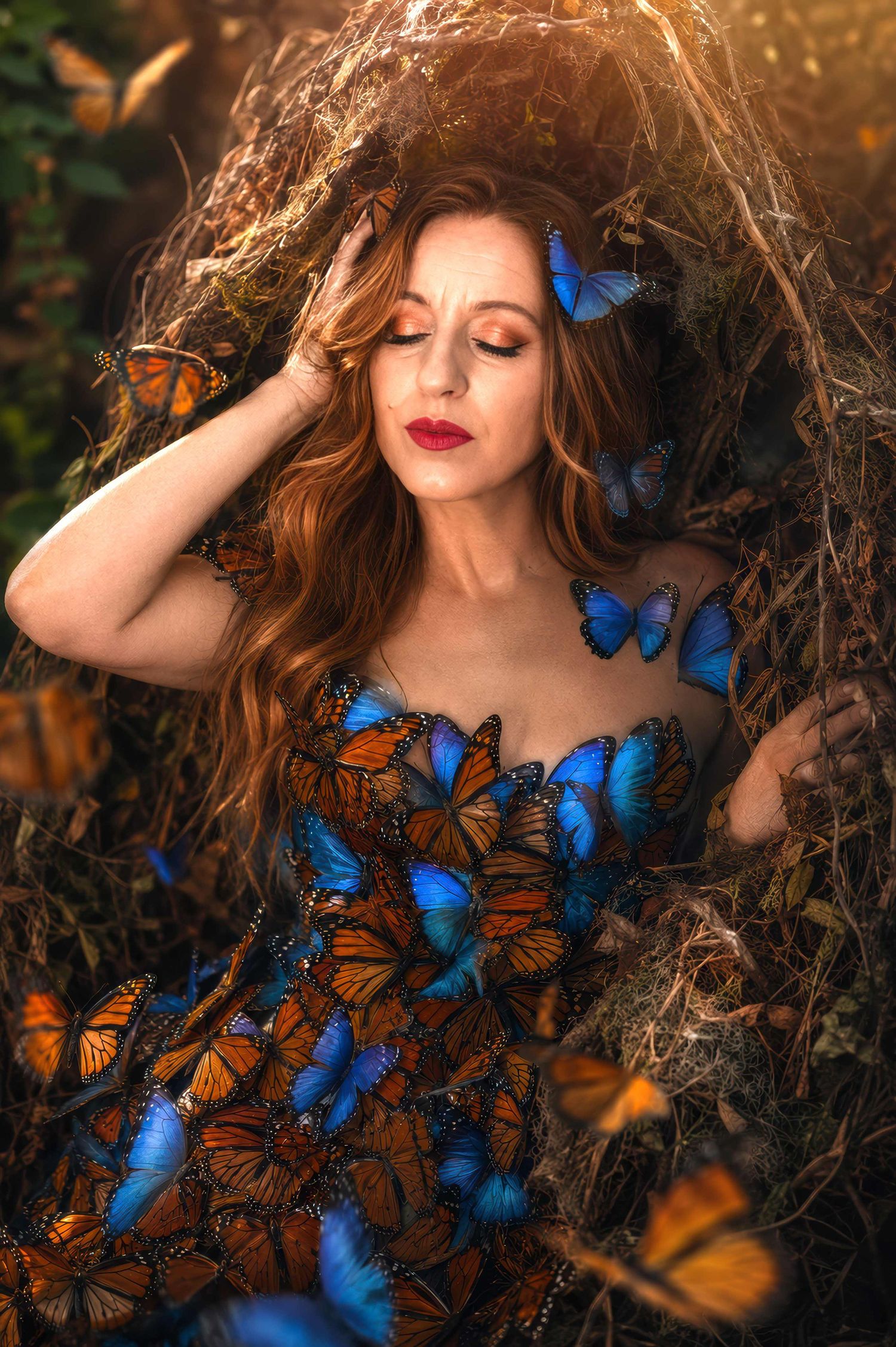 A woman with red hair poses with blue and orange monarch butterflies forming her dress in a golden nest.