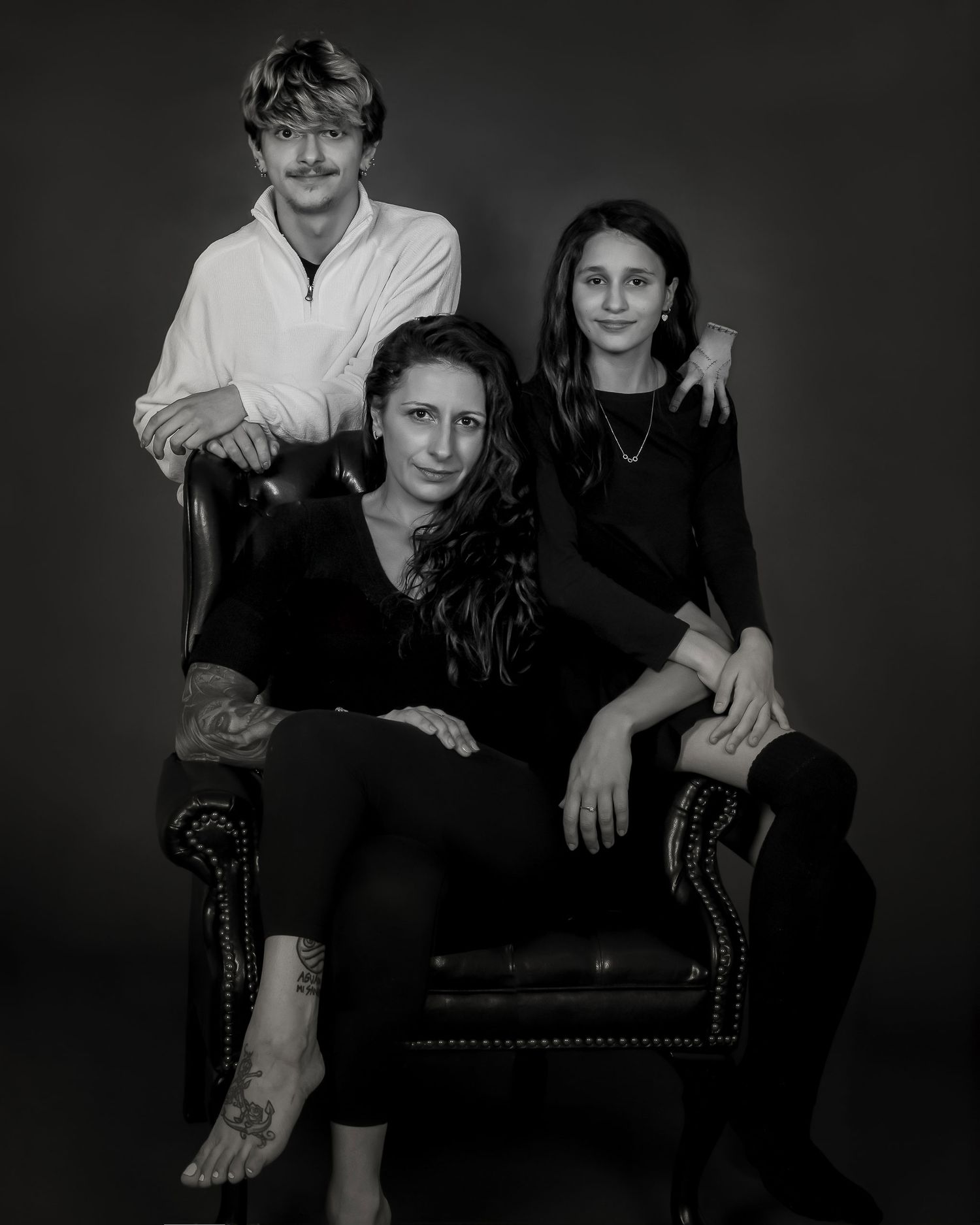 Black and white studio portrait of a mother and her two teenage children. an Ottawa studio Family portrait.
