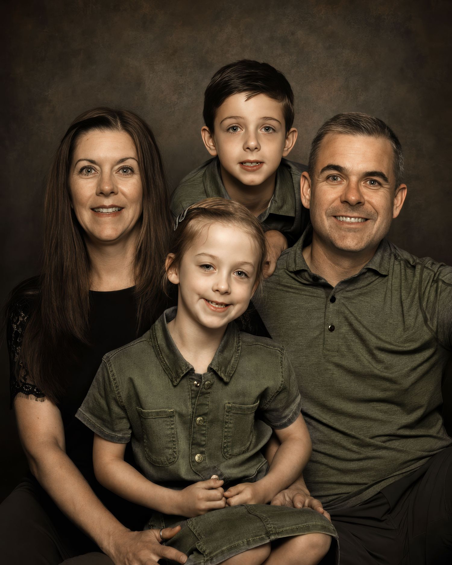 Family of four smiling in coordinated green outfits during a professional studio portrait session. an Ottawa studio Family fine art portrait