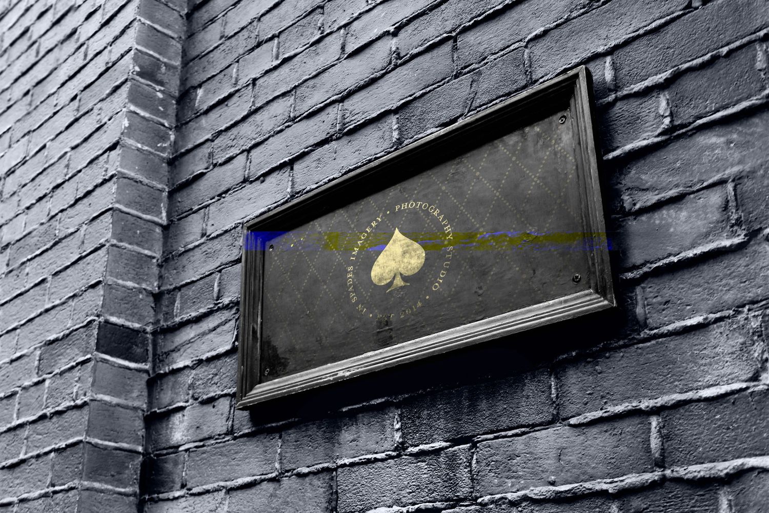 Gold heart logo framed on dark brick wall in moody urban setting.