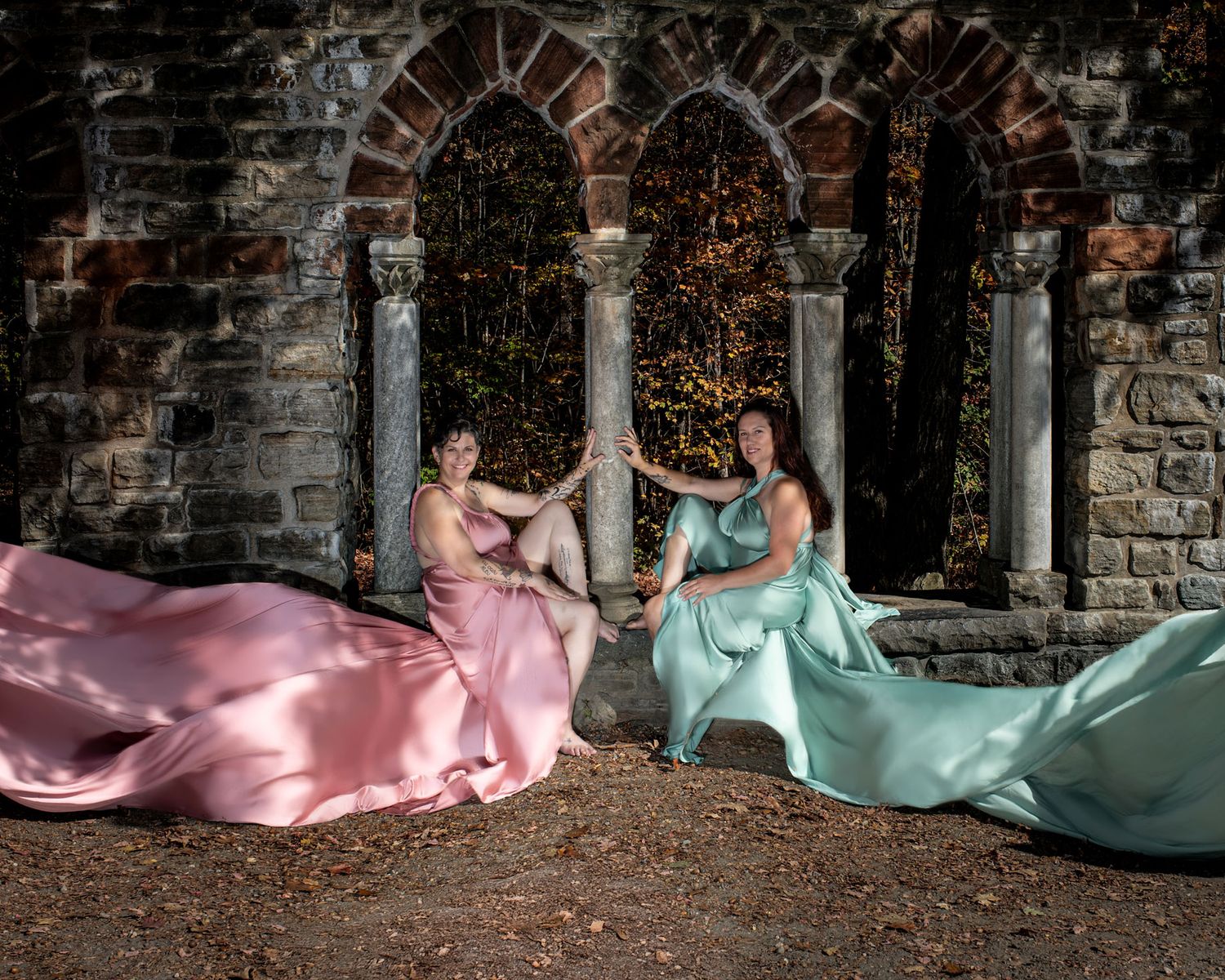 Two women in rose gold sage flying dresses pose at stone ruins.  Ottawa flying dress photography. Mackenzie King estate