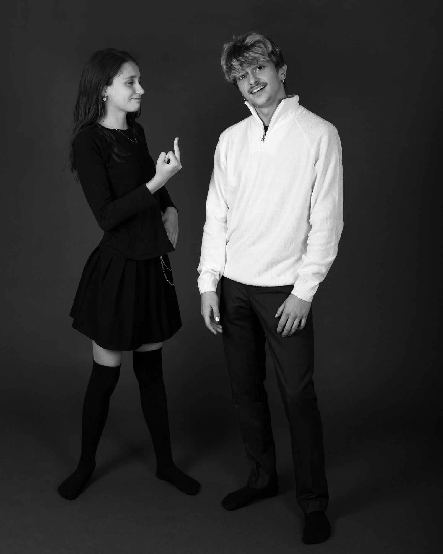 A teenage girl and boy pose playfully in black and white studio portrait wearing coordinated outfits. an Ottawa studio Family portrait