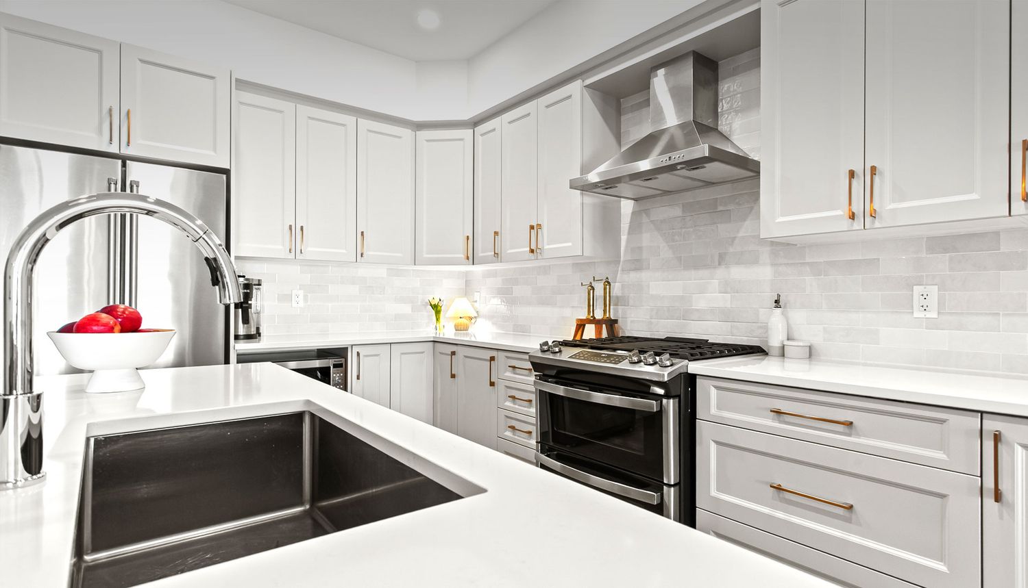 Ottawa real estate photography showcasing a bright modern kitchen with quartz countertops, subway tile backsplash, and stainless steel