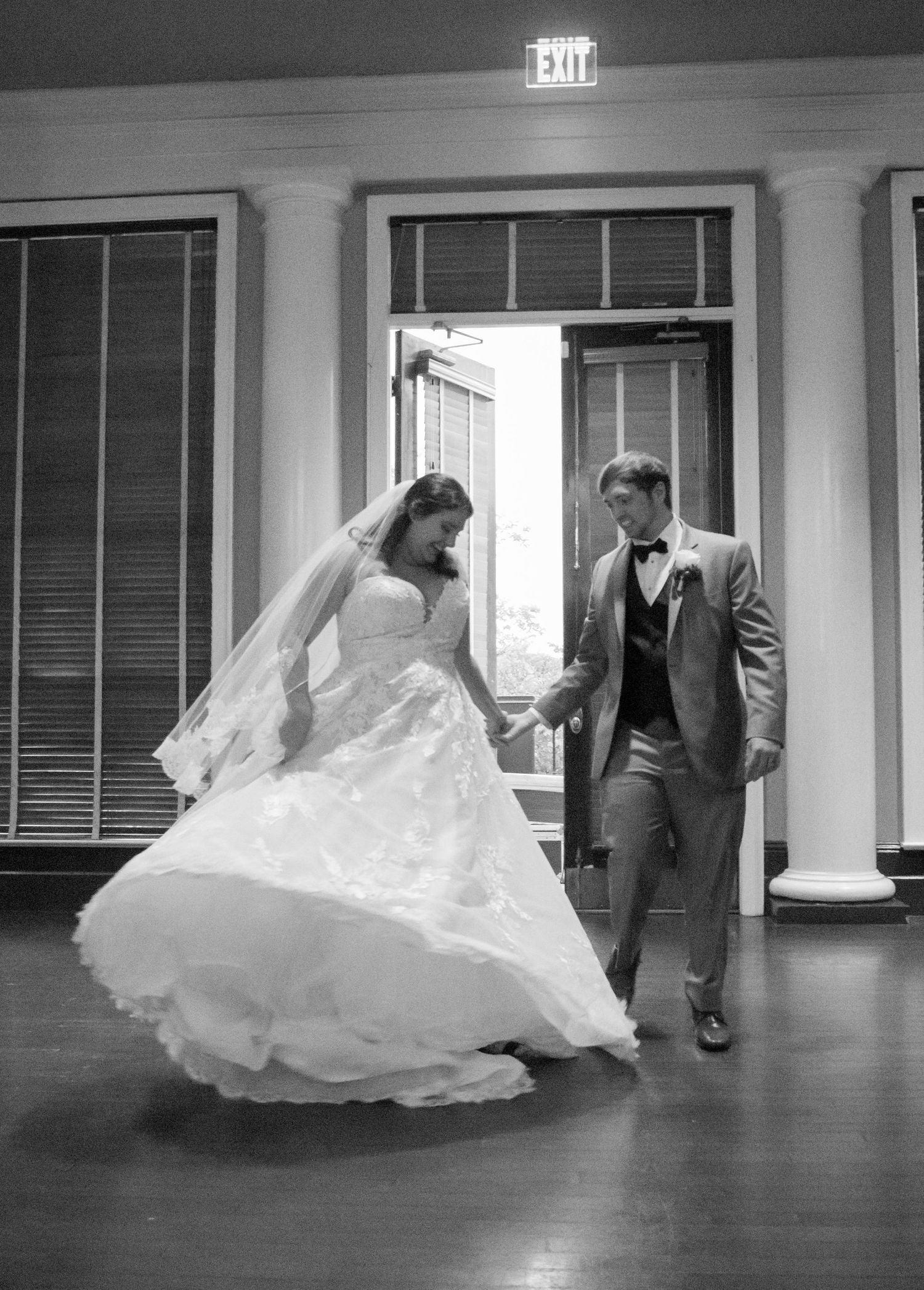 black and white candid bride and groom entrance