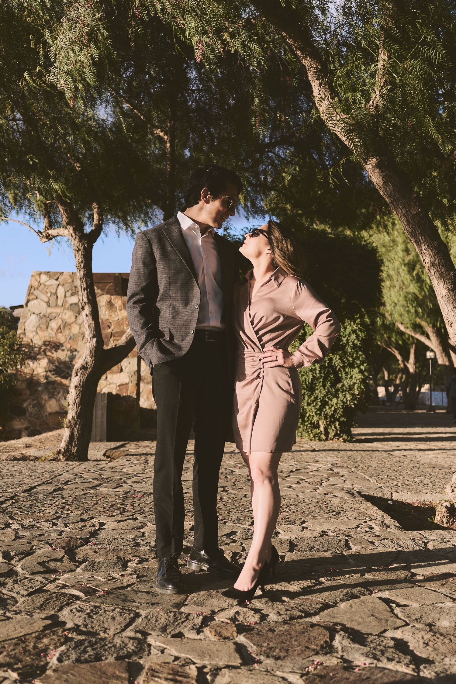 Stylish engagement session photographed among rocky terrain and trees.