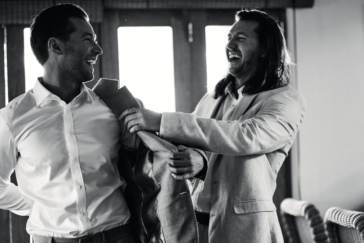 Black and white photo showing joyful preparations and candid moments during a wedding celebration.