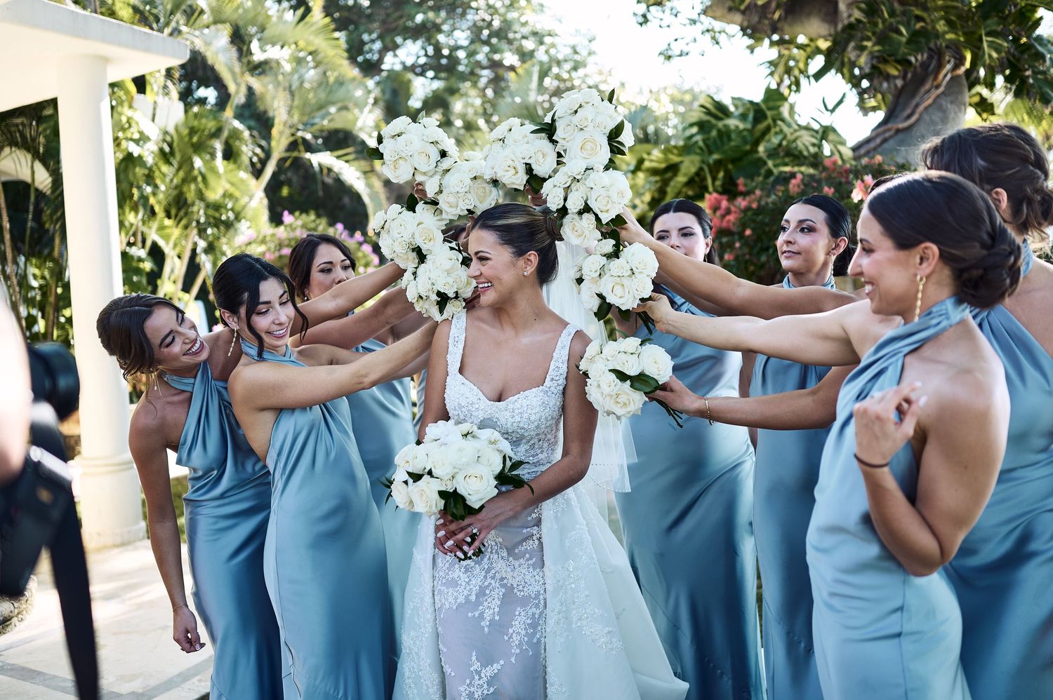 Bridesmaids in light blue dresses share a joyful moment during wedding celebrations.