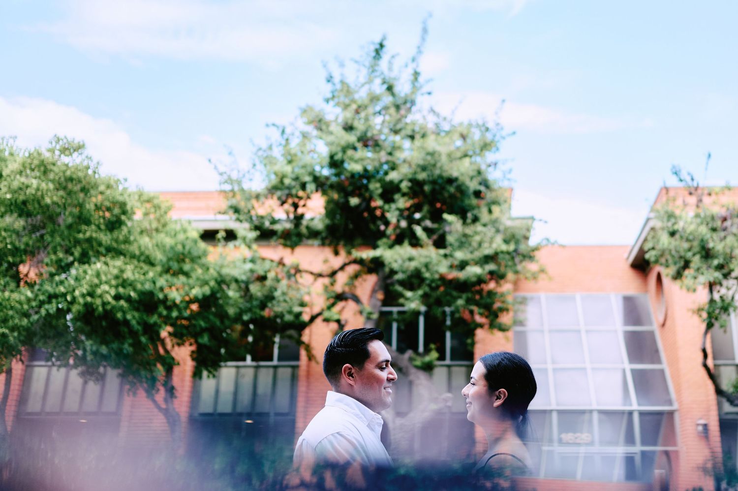 Blurred outdoor photography setup with lighting equipment and trees in background.