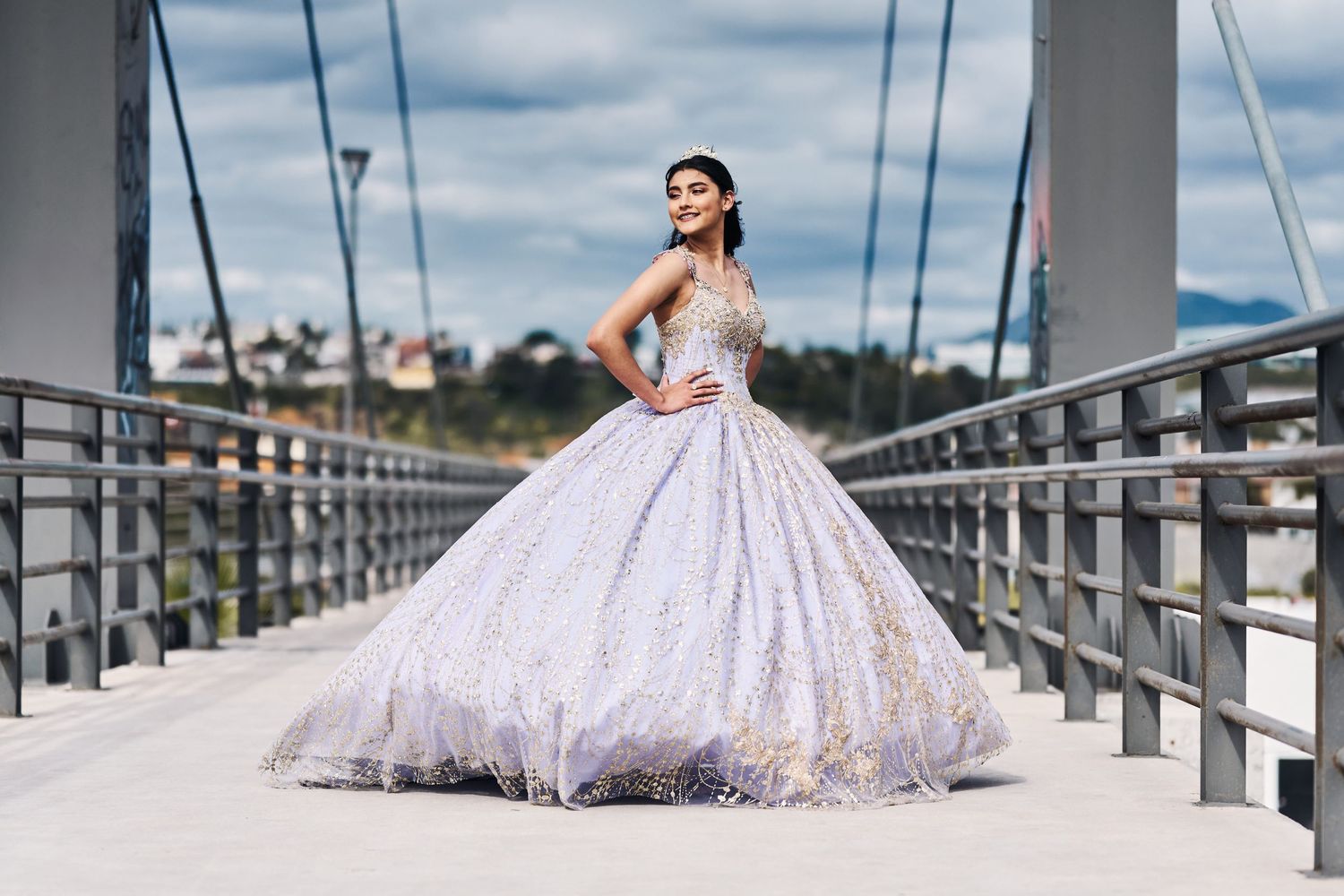 Stunning wedding dress with full skirt photographed on a modern bridge walkway.