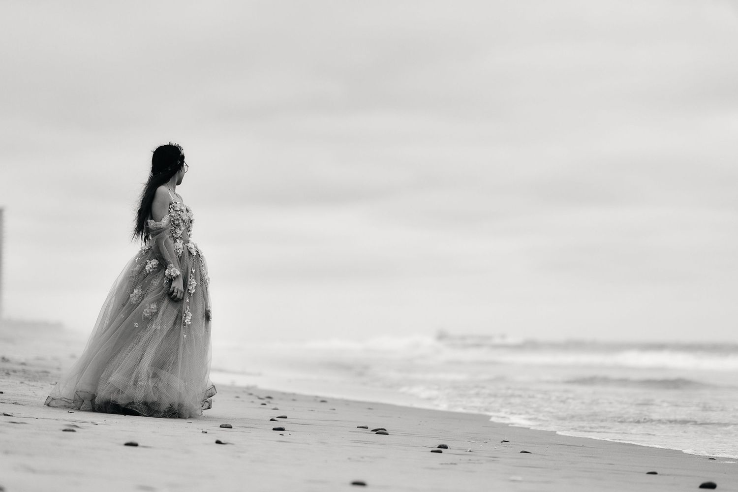 A flowing white dress silhouetted against a misty beach landscape.