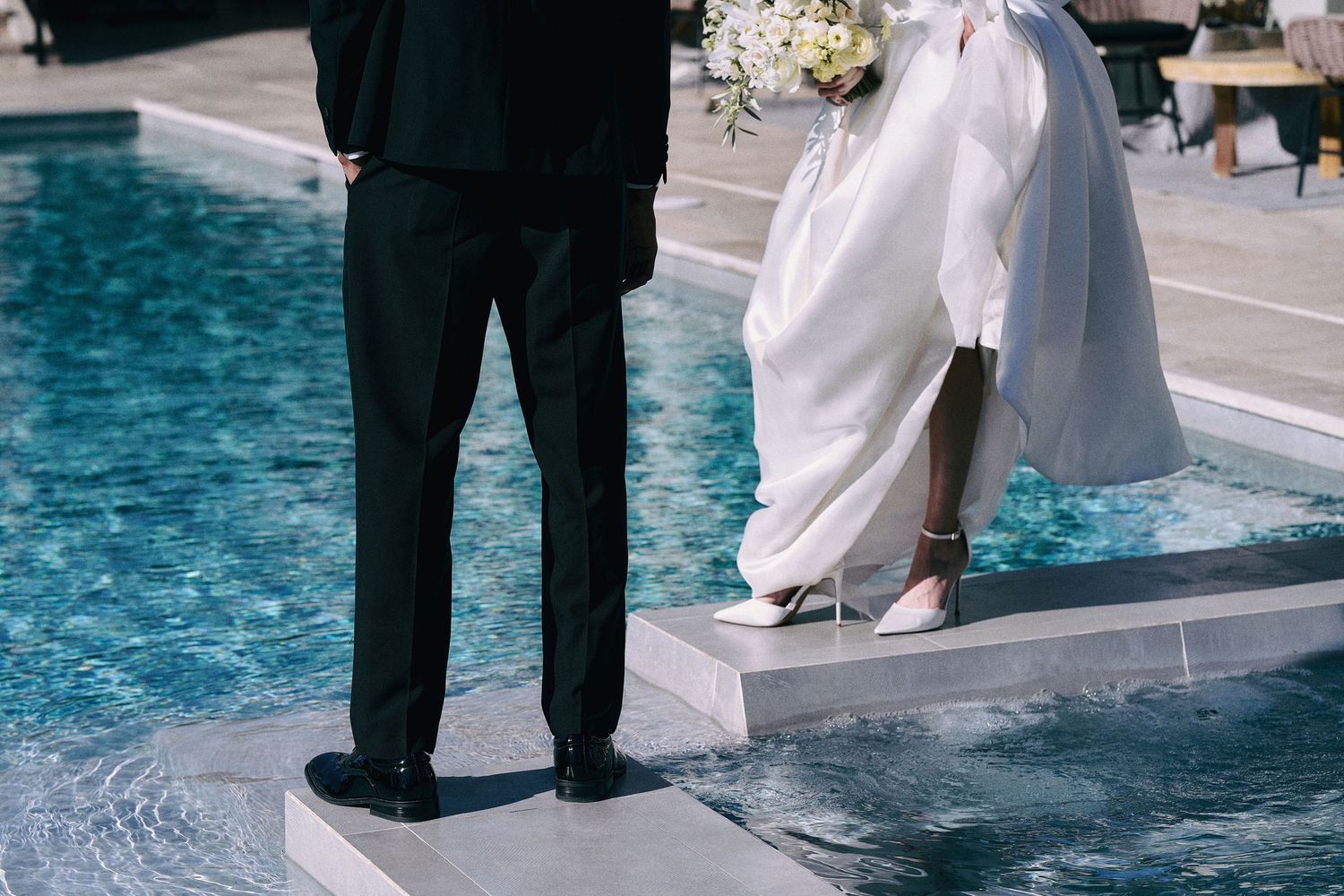 Wedding guests gather around a poolside venue during a celebration.
