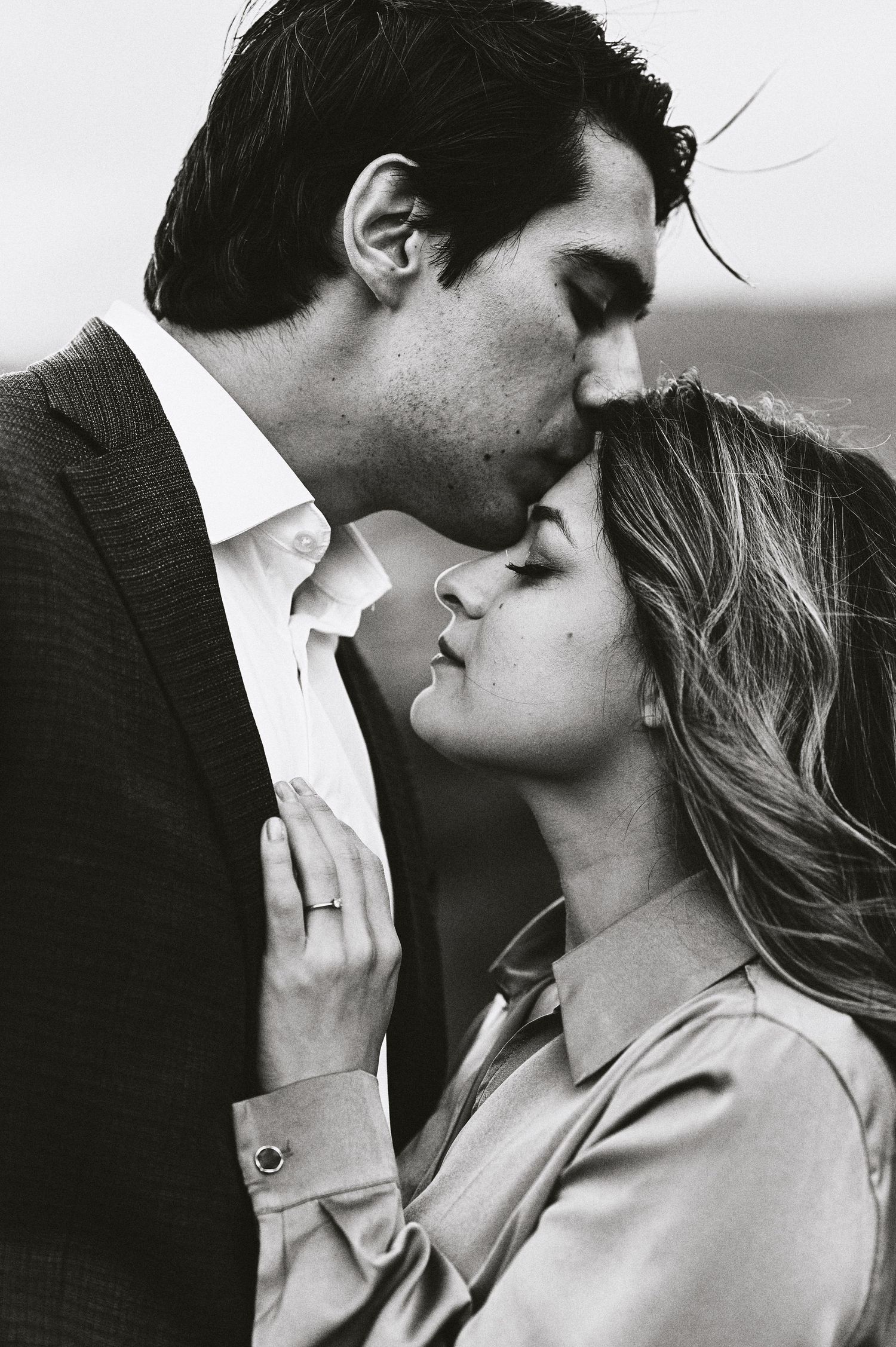 Intimate black and white portrait of a romantic couple sharing a tender moment.