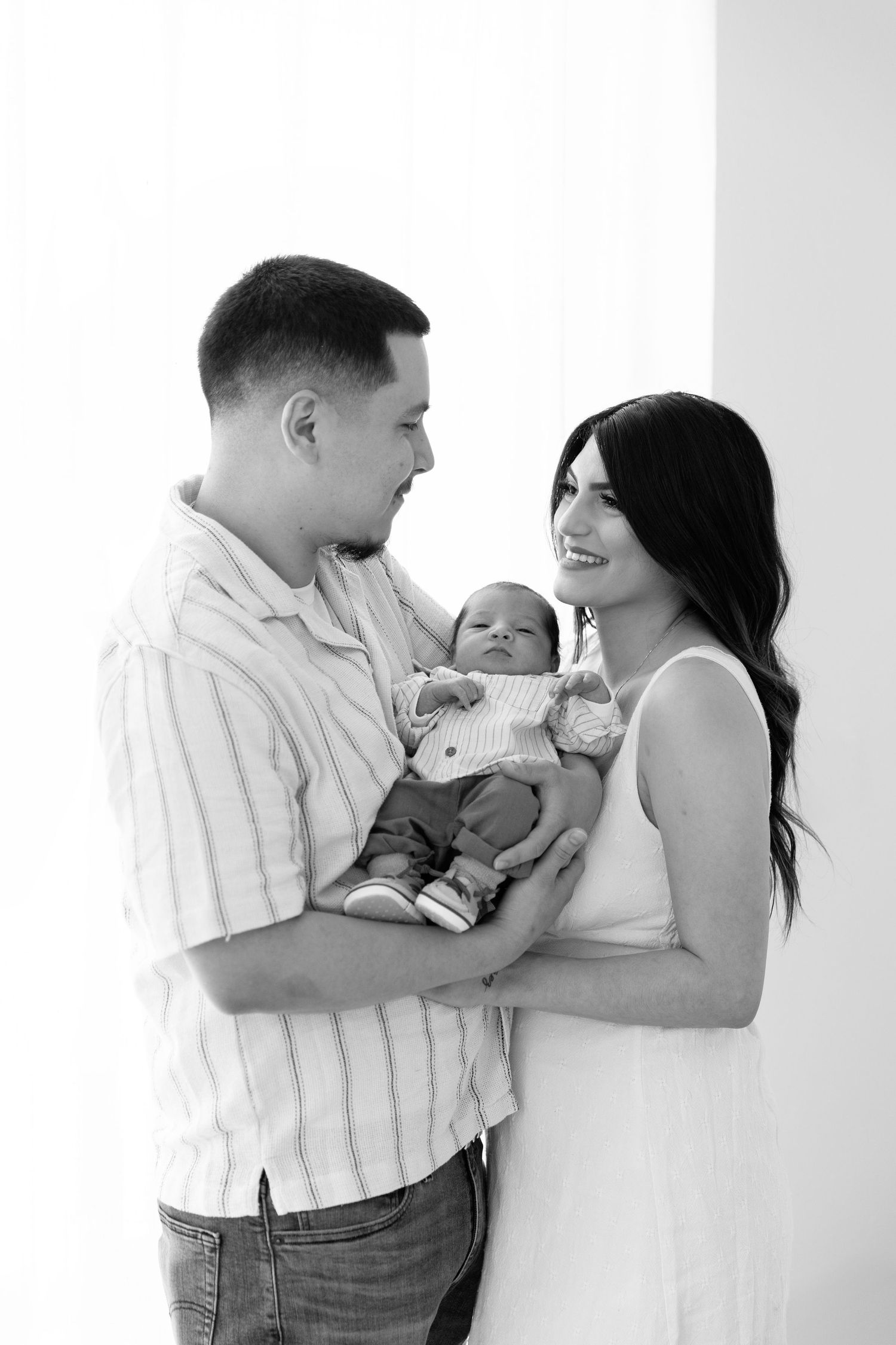 Black and white family portrait series showing tender moments with newborn.  Located in Palm Desert, California.