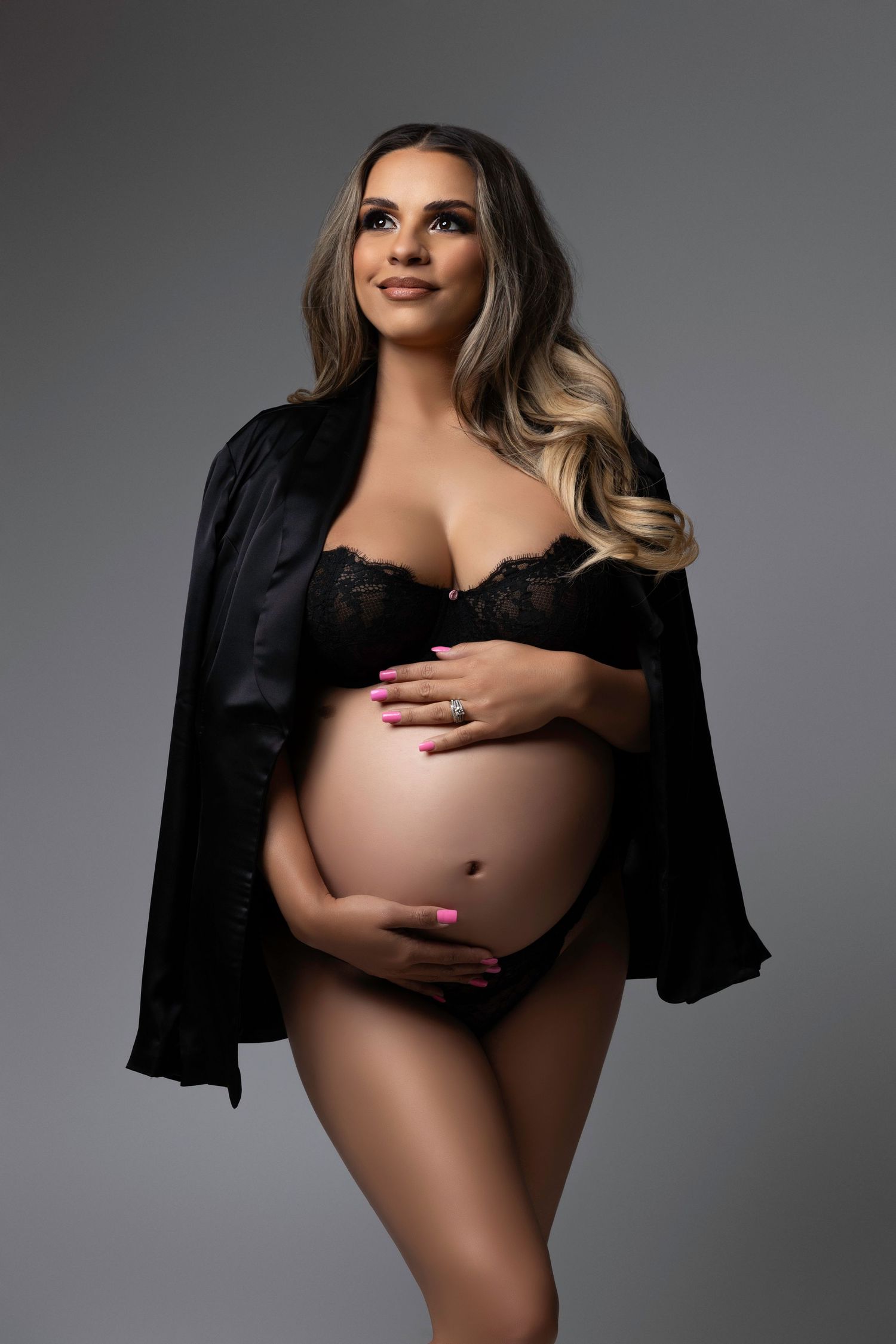 Glamorous maternity photos with black robe against grey studio background.  Located in Palm Desert, California.