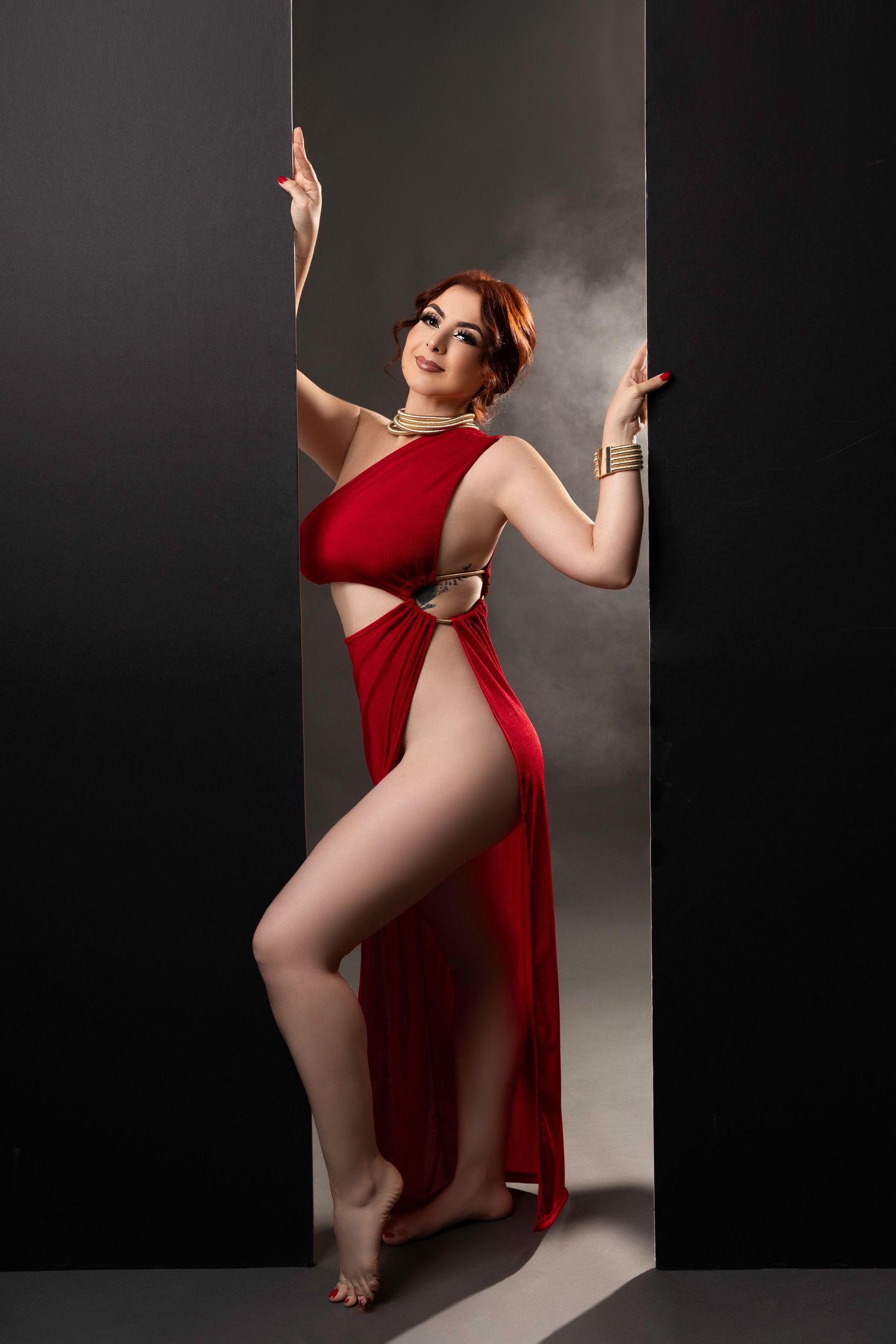 Artistic portrait series in dark studio featuring dancer in flowing red dress against dramatic lighting and shadows.