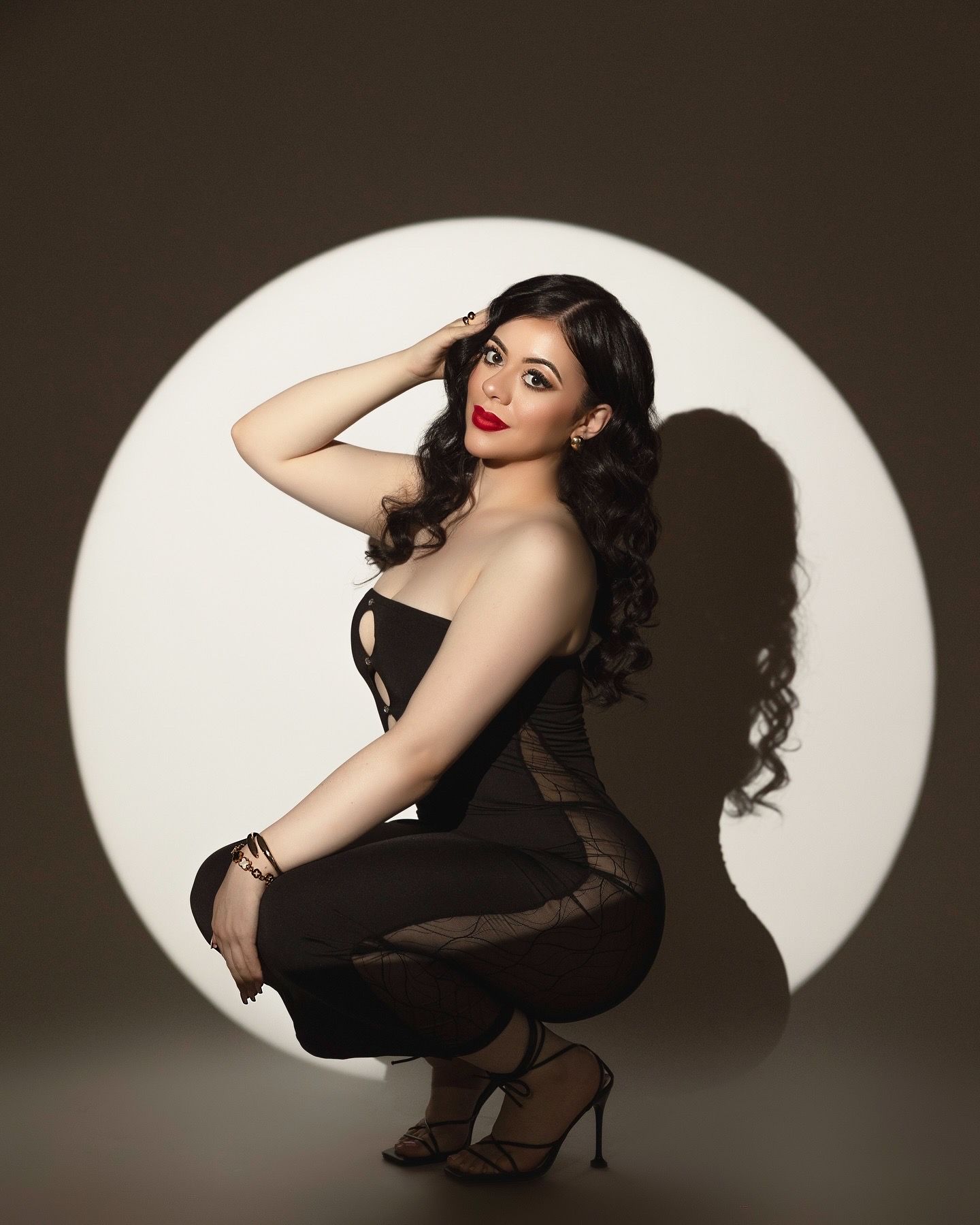 A series of dramatic pinup-style portraits with vintage styling against a dark background with circular spotlight effects.