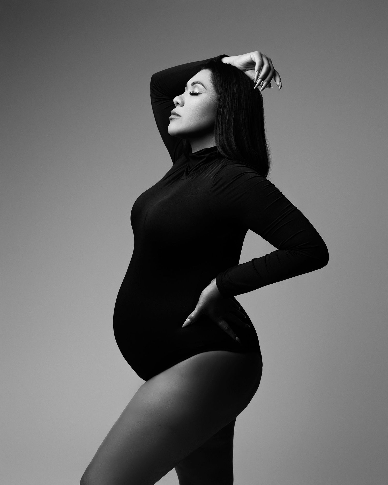 Artistic black and white maternity photo series showing silhouette poses against dramatic lighting.
