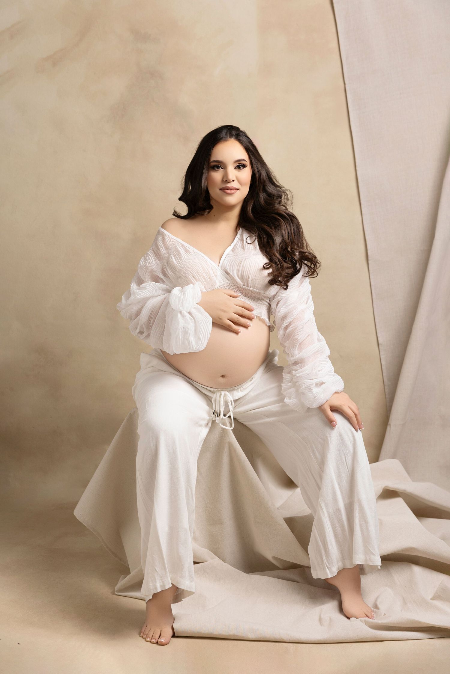 A woman in a flowing white dress poses gracefully against a neutral backdrop in a series of artistic portraits.
