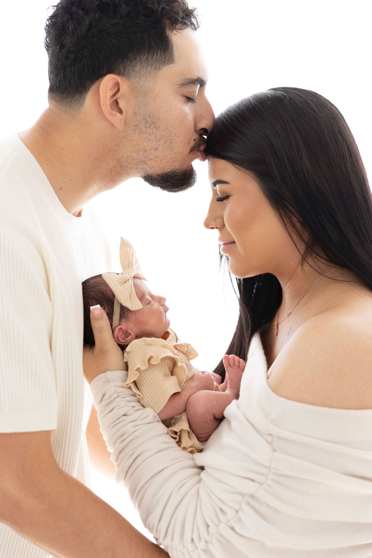 A series of intimate newborn photos showing tender moments with a baby in white.  Located in Palm Desert, California.