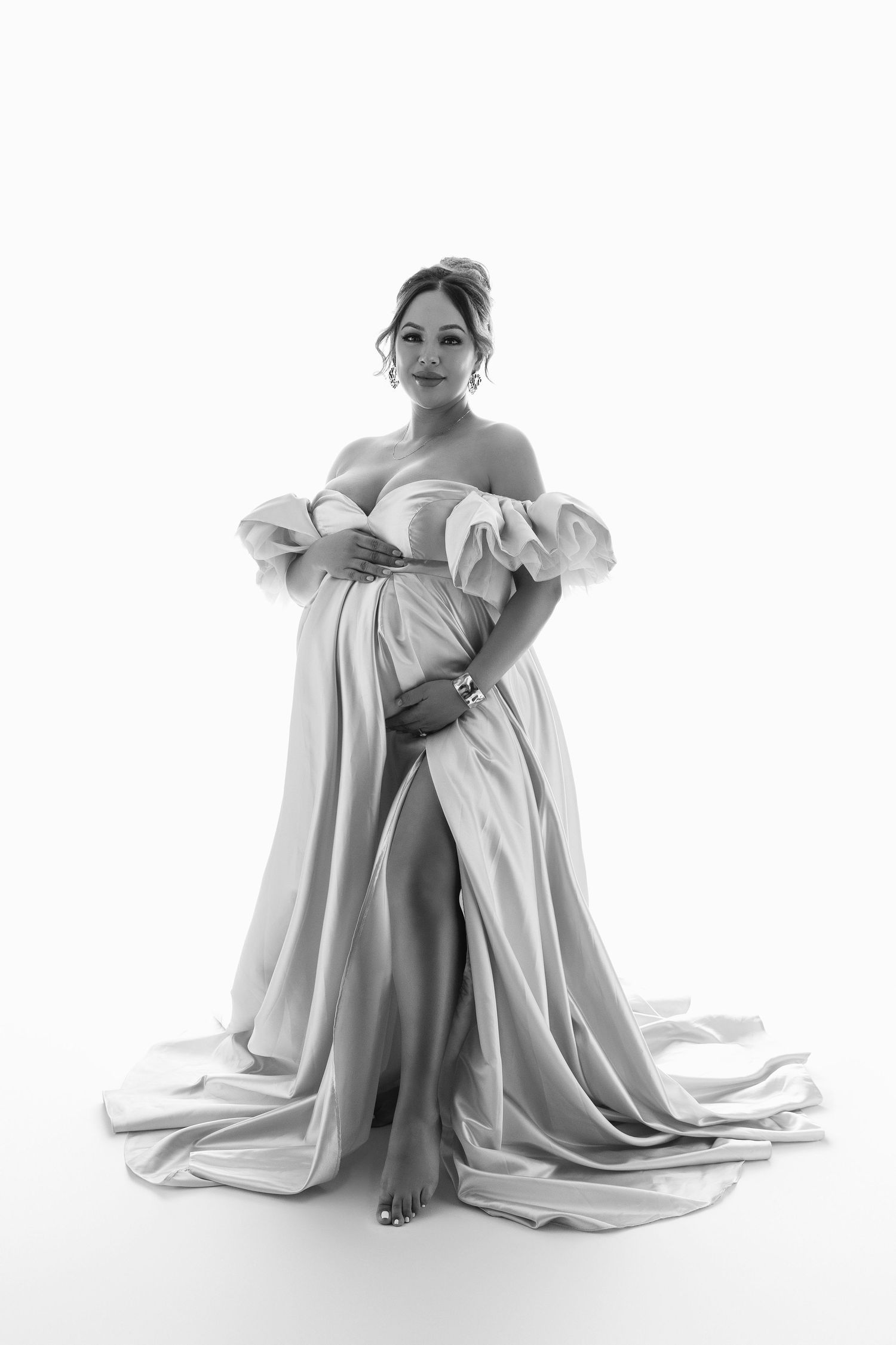 Artistic black and white portrait series showing figure draped in flowing white fabric against white background.