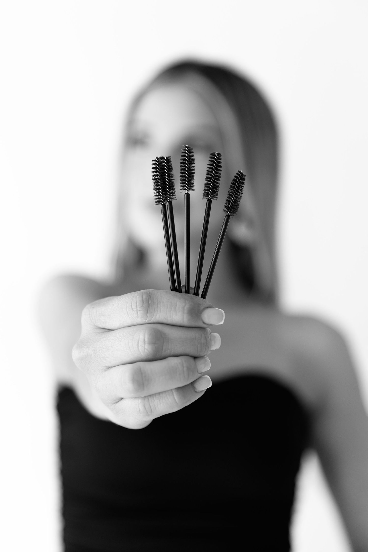 Artistic black and white photo series showing hands holding makeup brushes.  Located in Palm Desert, California.