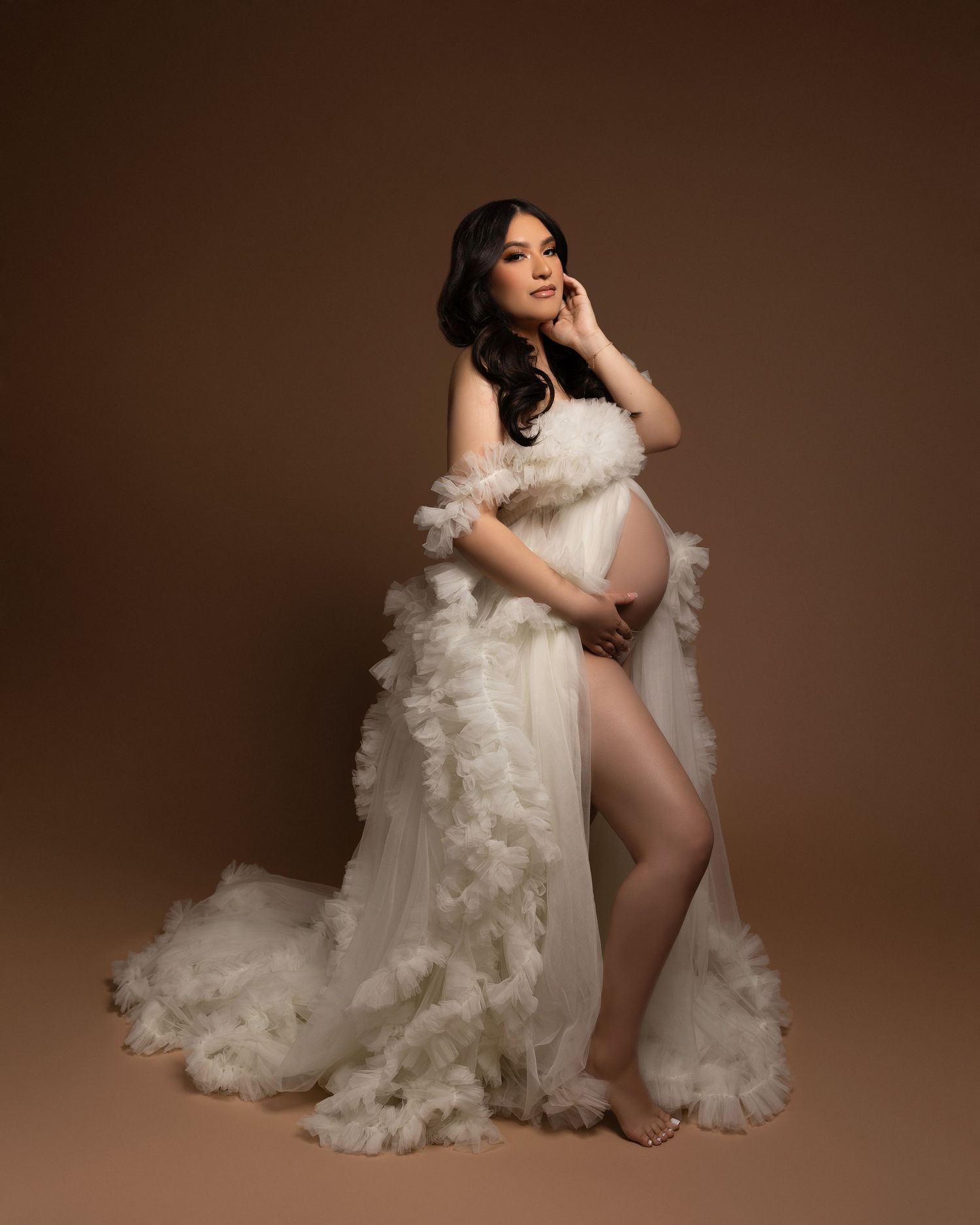 Artistic boudoir photography series featuring flowing white fabric and elegant poses against a brown studio backdrop.
