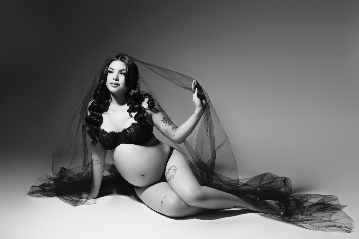 A black and white artistic photo series showing a figure draped in flowing sheer fabric creating ethereal poses.