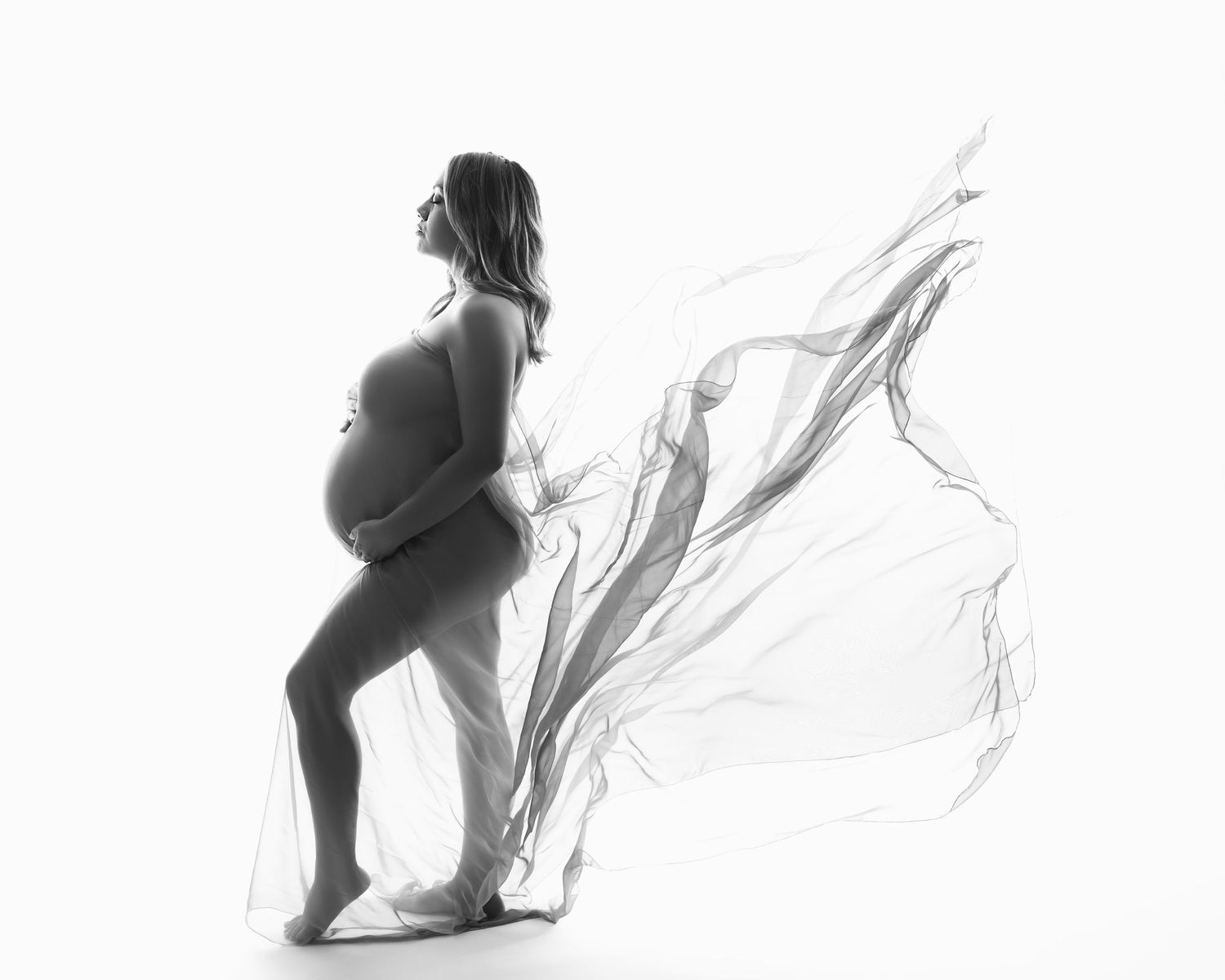 Minimalist black and white maternity silhouettes showing graceful movement and flowing fabric.  Located in Palm Desert, California.