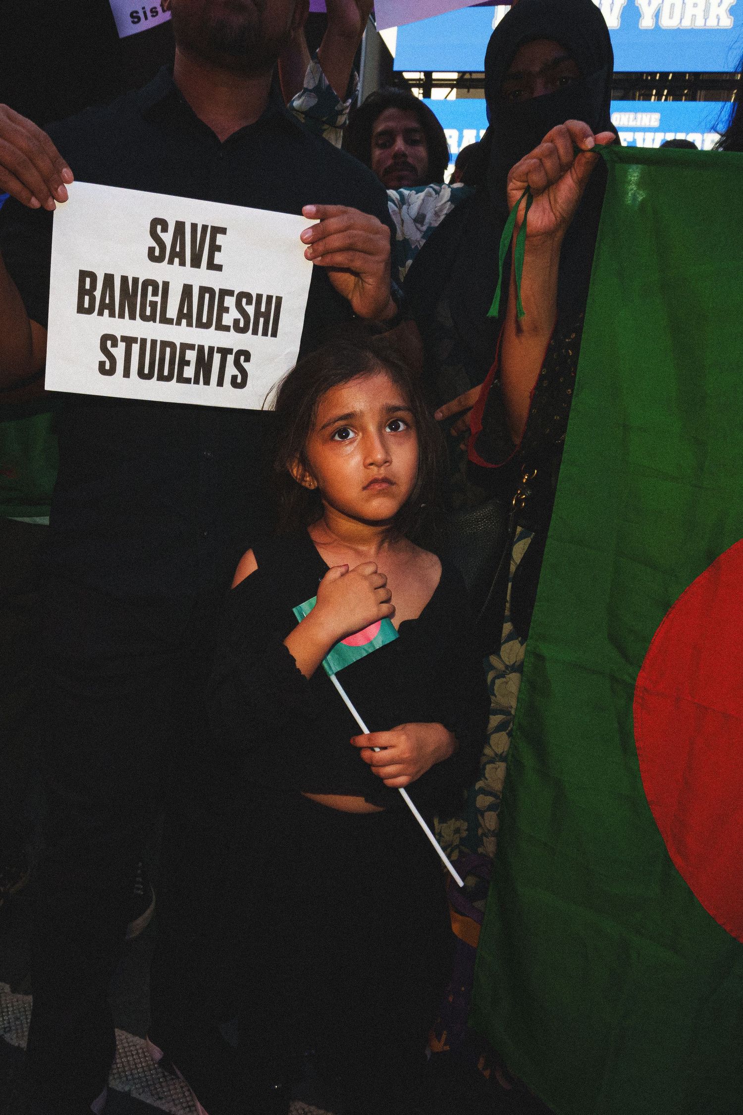 Young girl holding Bangladeshi flag at a Save Bangladeshi Students protest.