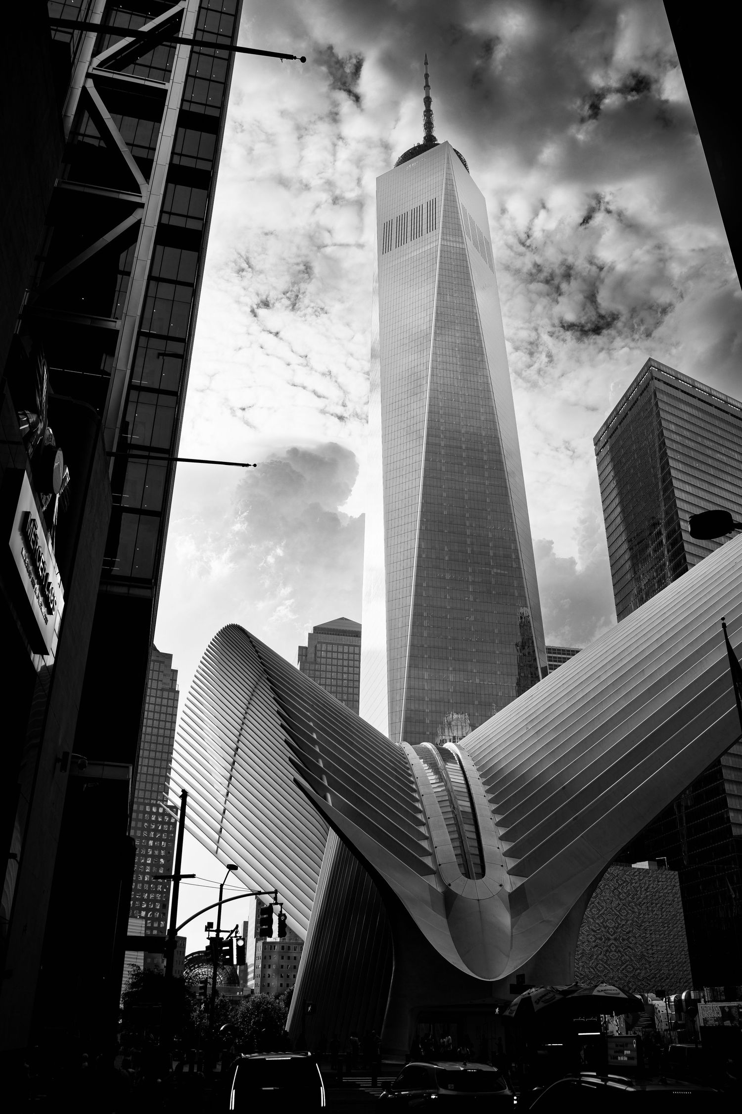 Black and white dramatic low-angle view of One World Trade Center and the Oculus transit hub in NYC.