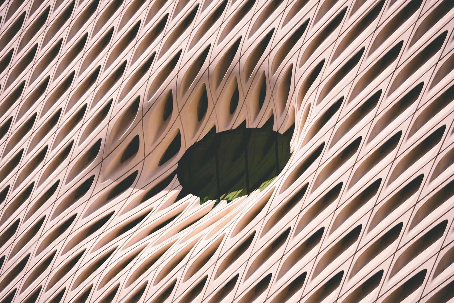 Abstract architectural detail of The Broad museum facade with a wavy honeycomb pattern and oval opening.