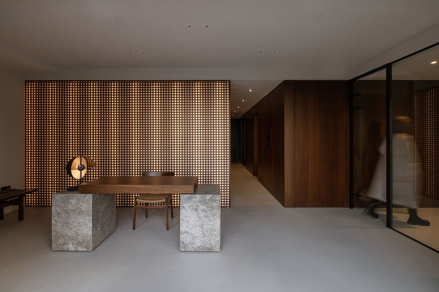 Modern interior design featuring wood paneling, concrete pillars, and minimalist furniture in a warm-toned living space by Studio Fluid.