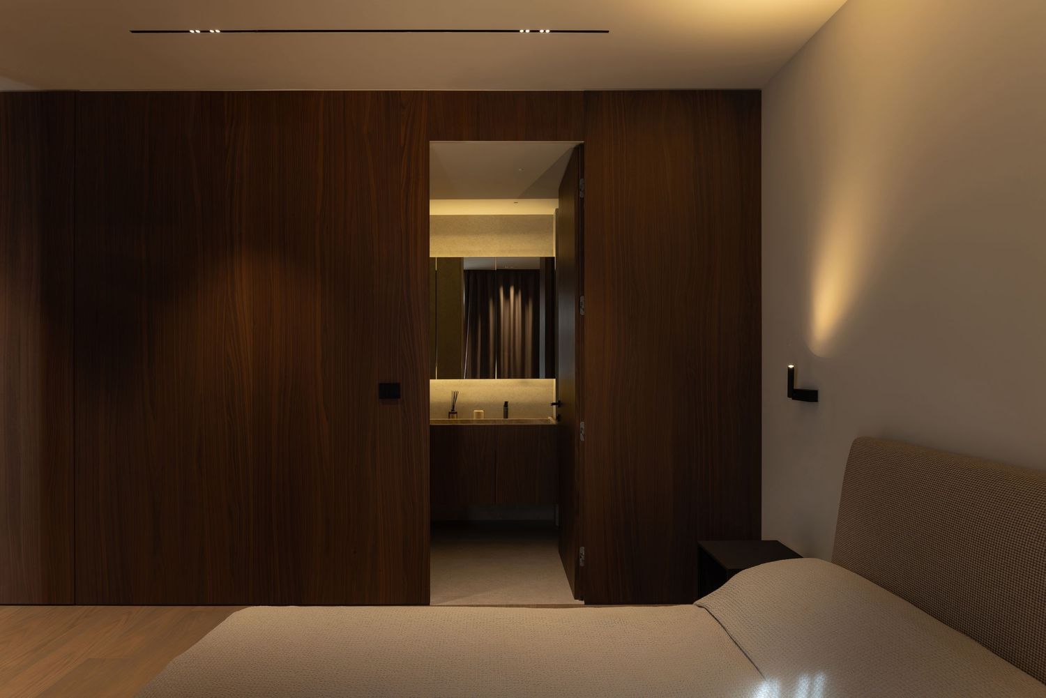Modern minimalist interior design featuring dark wood paneling and sleek lighting in a contemporary living space by Studio Fluid.