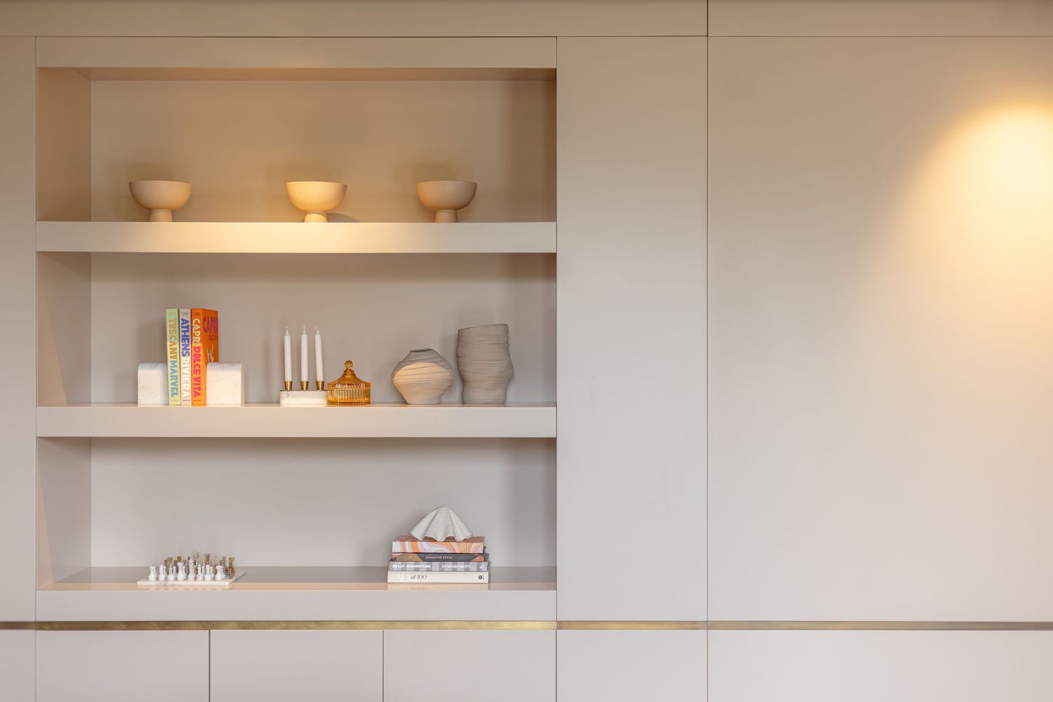 Beige interior with open shelving displaying Assouline books, ceramics and decorative items by Slavica Citakovic.