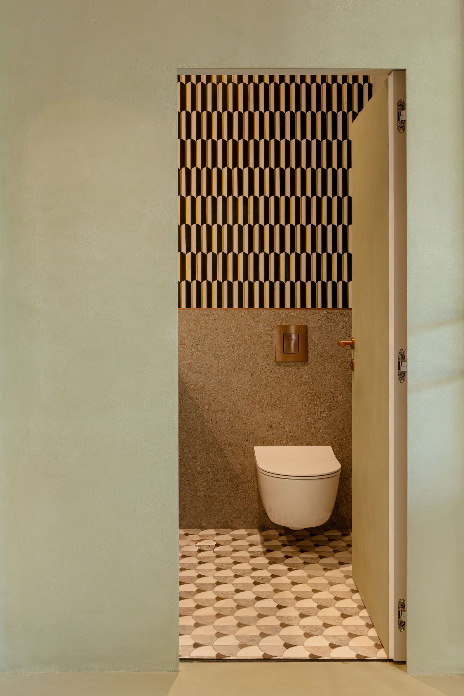 A modern bathroom interior with black and white geometric wallpaper and a white toilet against a beige wall by Modena Art Studio.