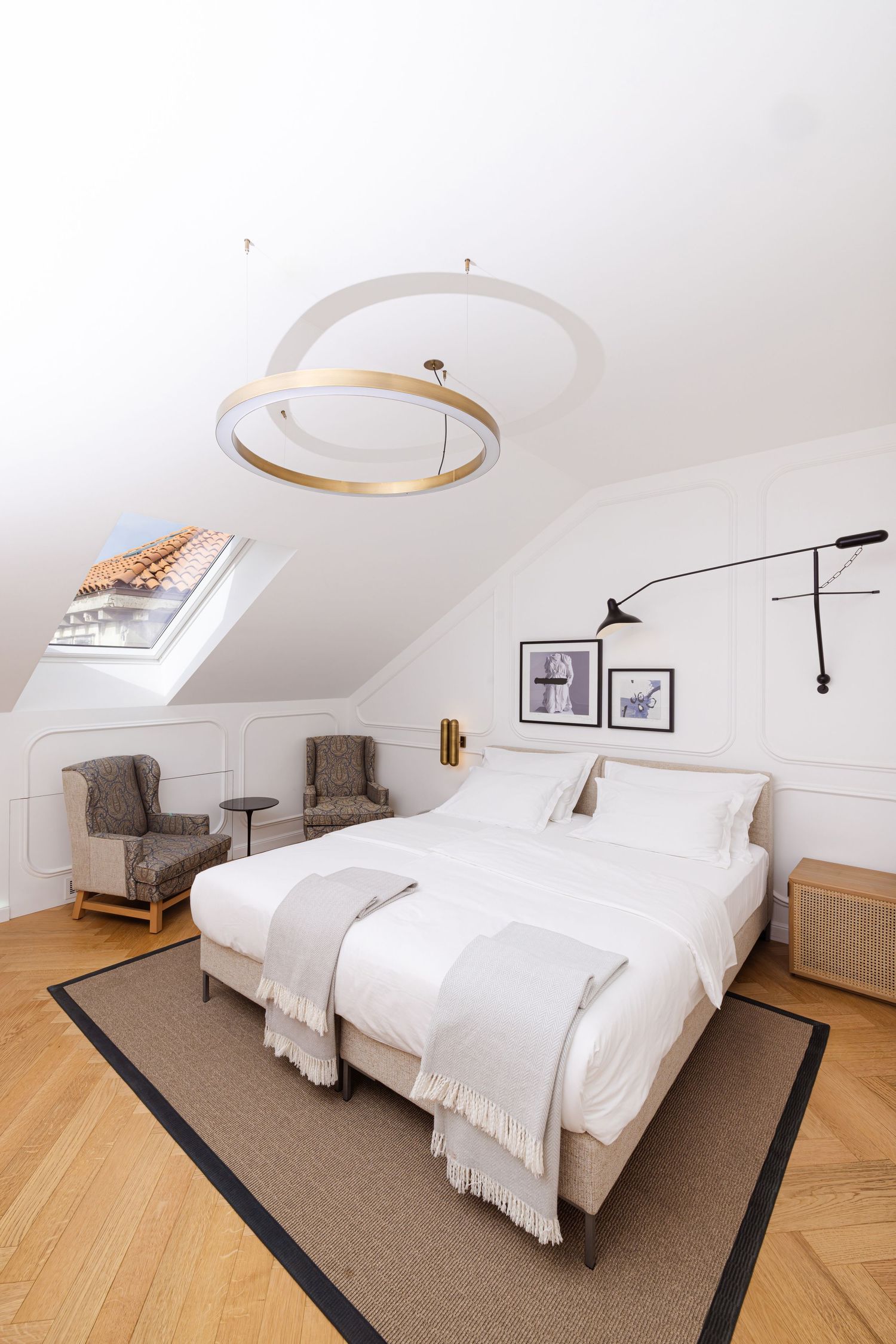 Modern bedroom interior with twin beds, hardwood floors, and sloped ceiling showcasing minimalist Scandinavian design.