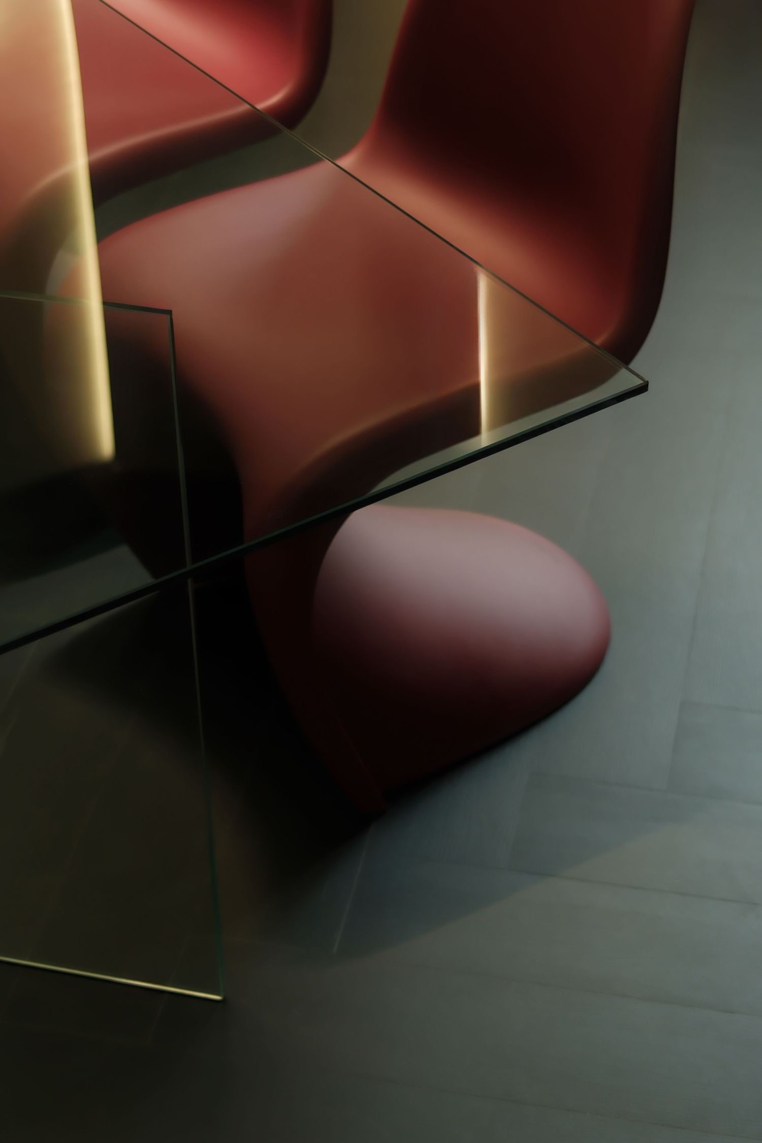 Close-up views of a modern red leather chair from different angles in a dimly lit room.