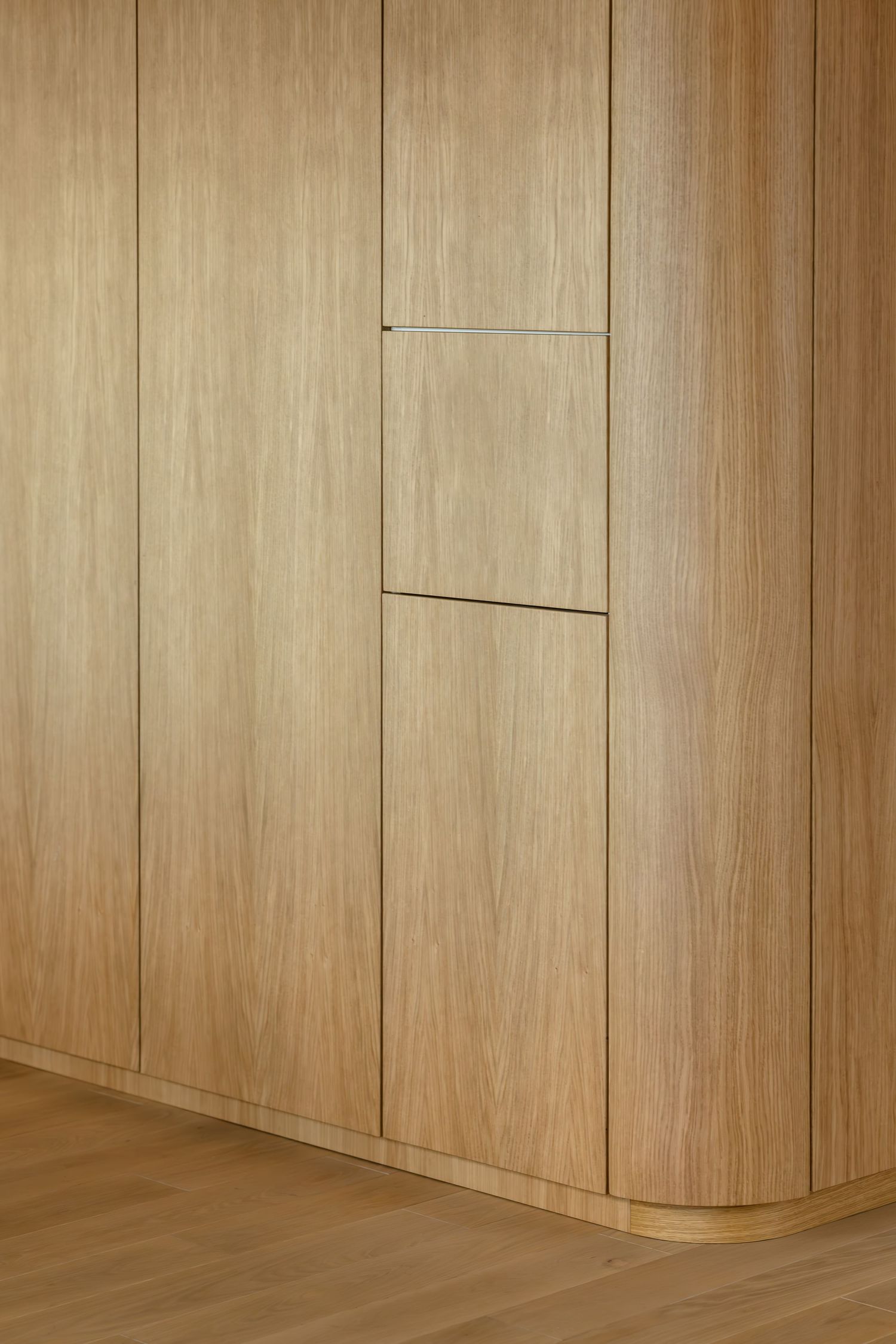 Light wood paneled wall with vertical planks and seamless baseboards in modern minimalist interior design by Studio Dizajning.