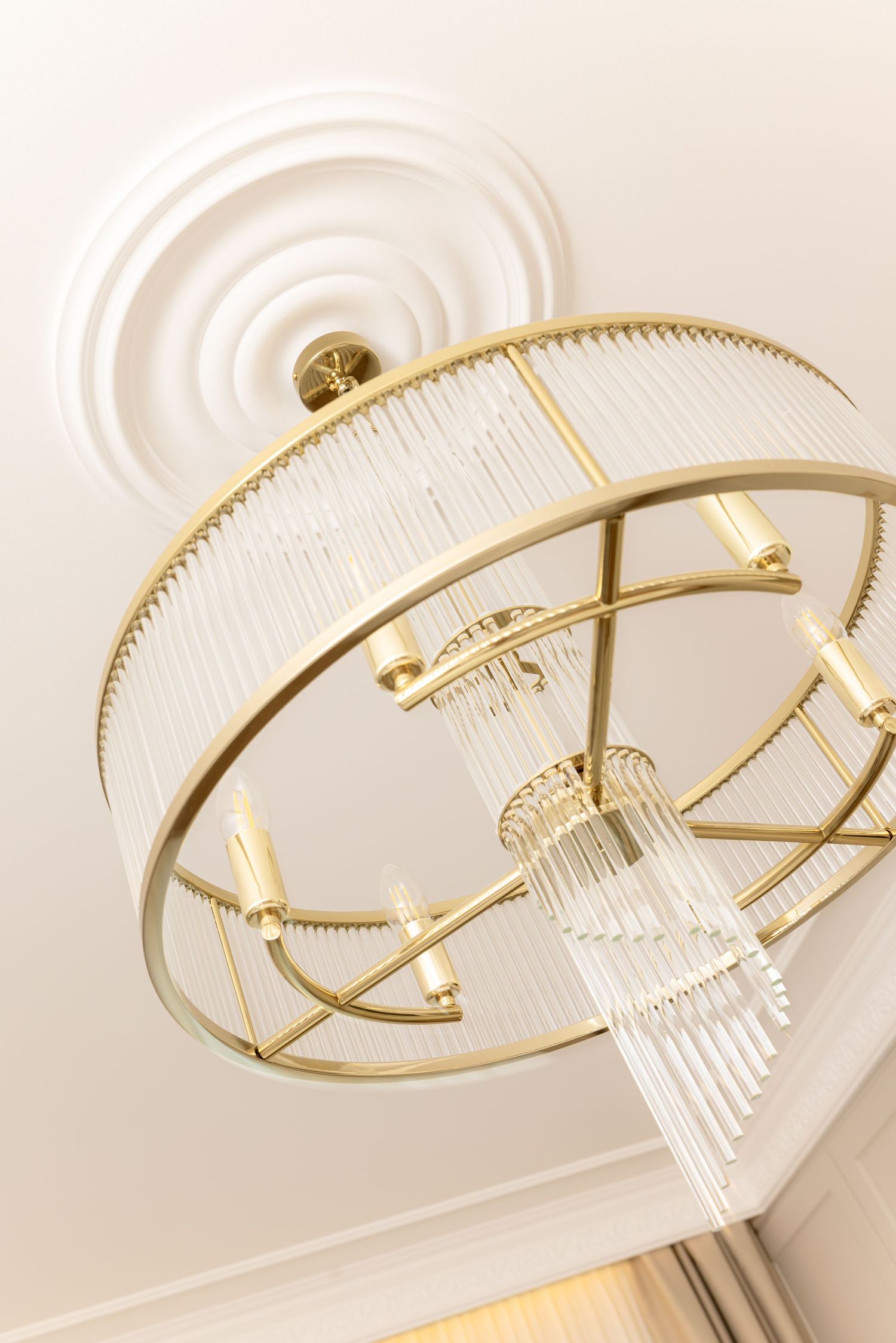 Modern gold and crystal chandelier with geometric design photographed from different angles against a white ceiling by Vedrana Markovic.