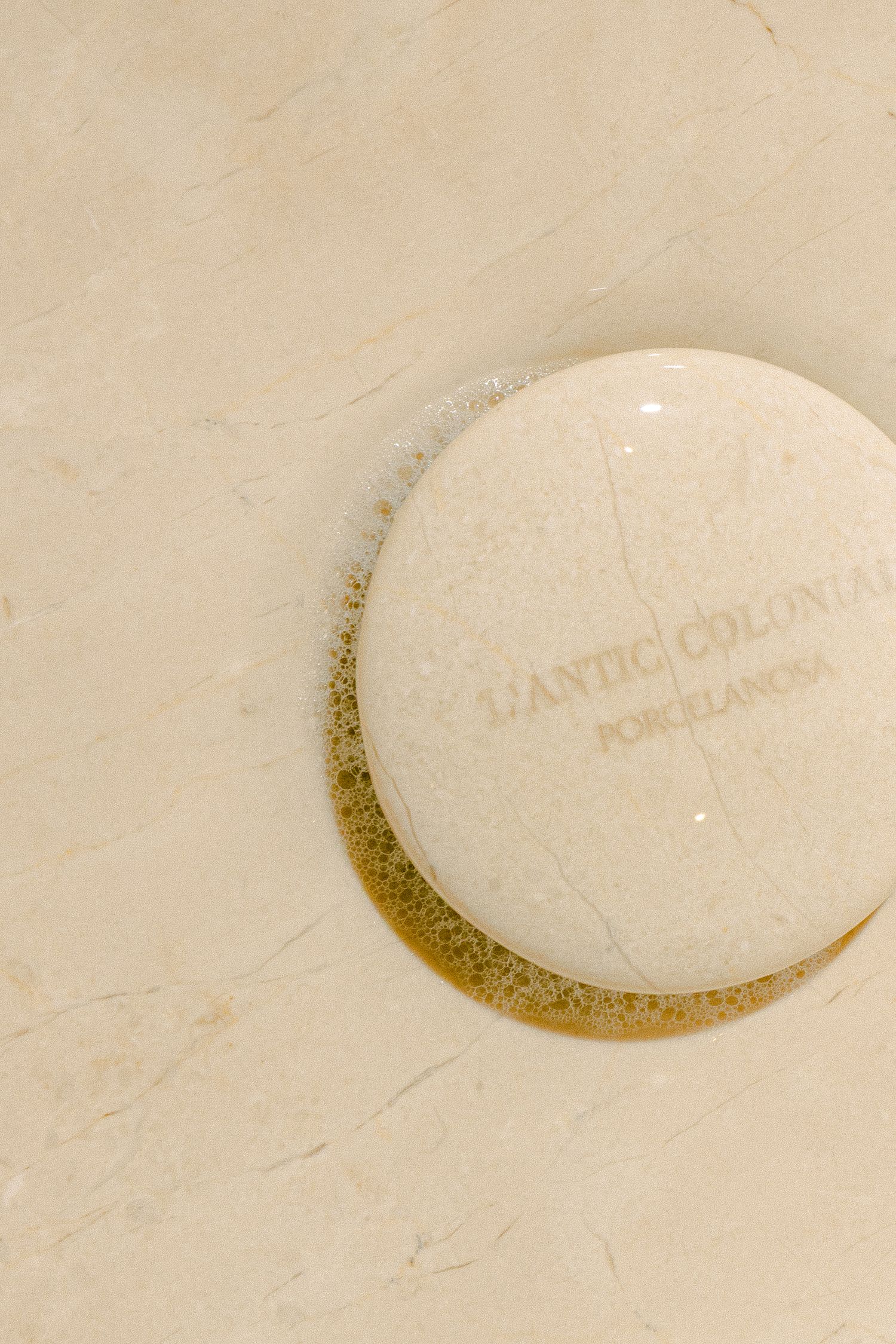 A sequence of four close-up photos showing a porcelain dish with text being gradually covered by a spreading liquid.