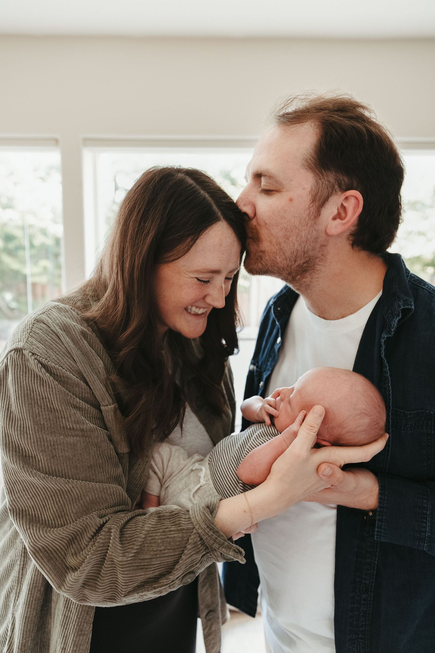 A playful and intimate candid photo series of a couple laughing and sharing tender moments together indoors.