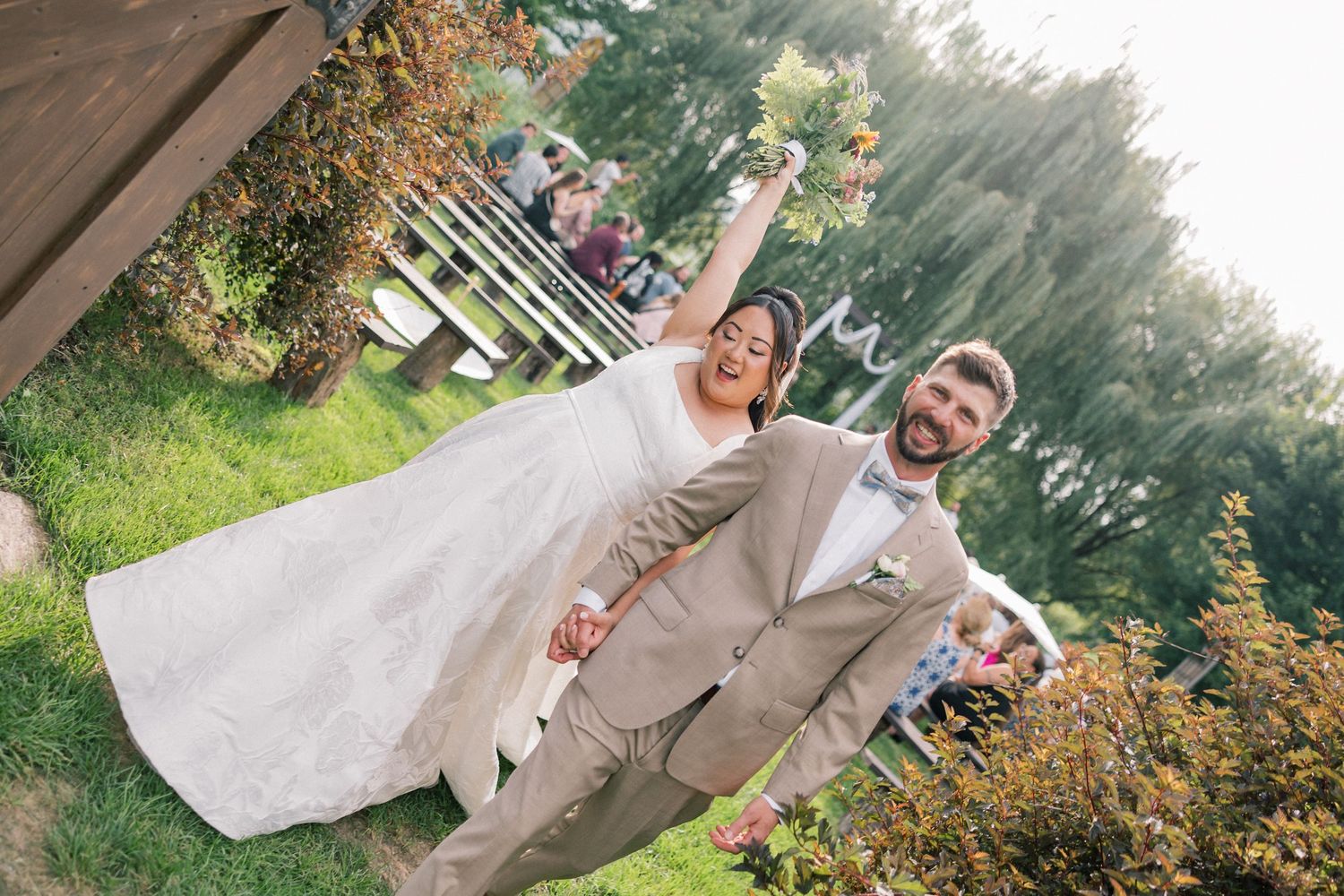 Newlywed couple shares joyful moment together in outdoor garden setting.