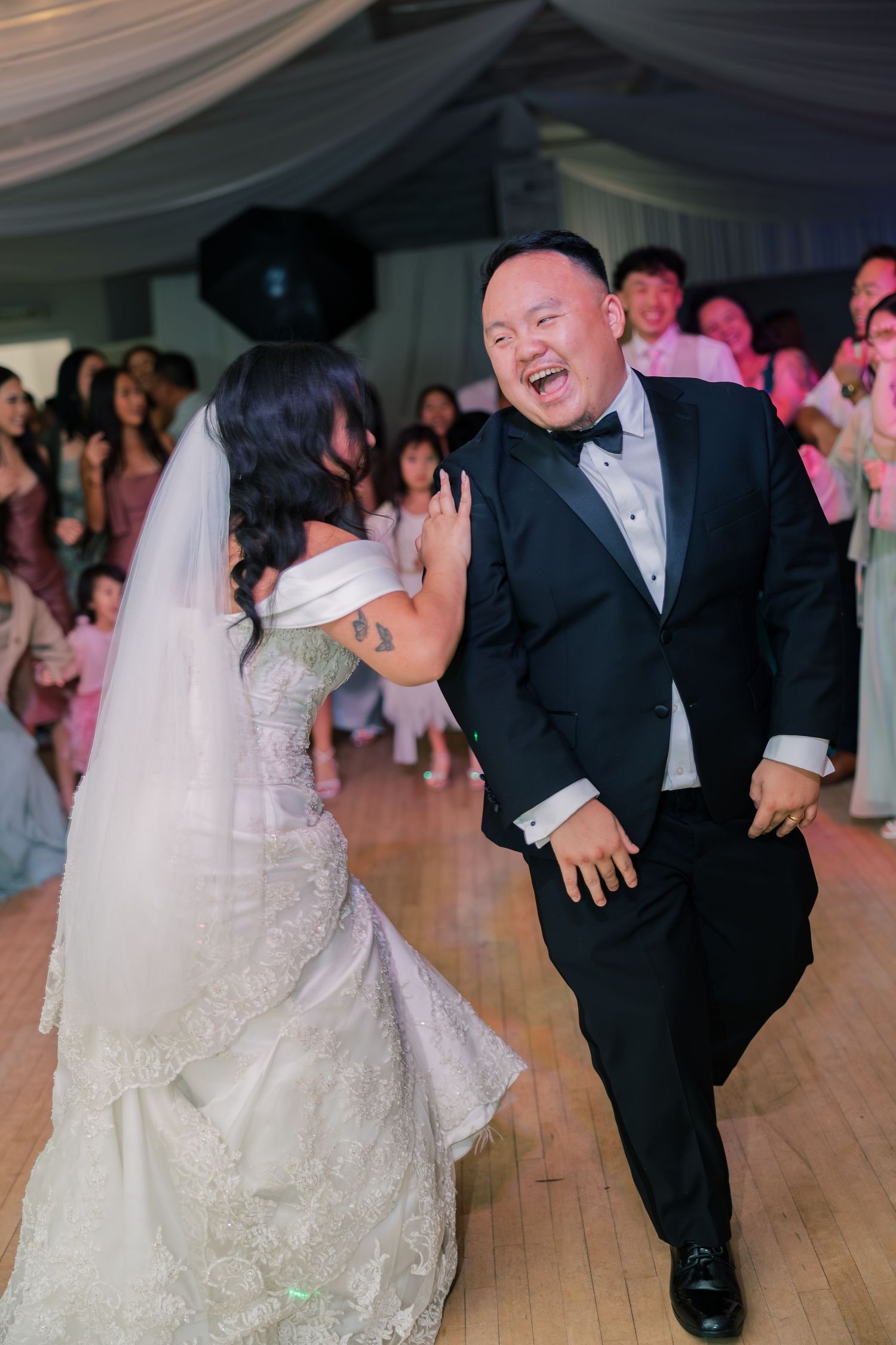 Wedding reception dance floor with guests celebrating in formal attire.