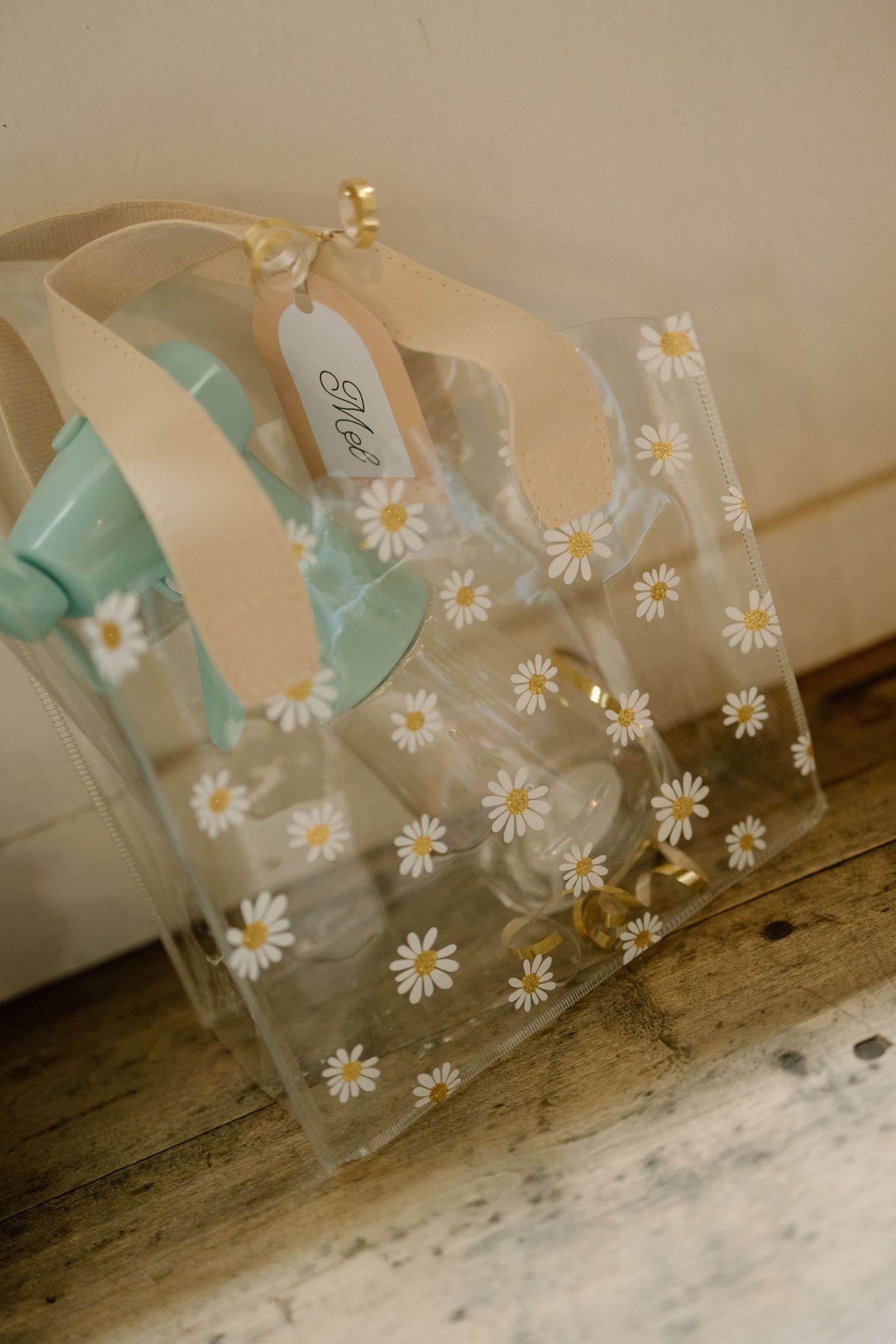 Decorative glass jars adorned with daisies and mint green ribbons arranged in a row.