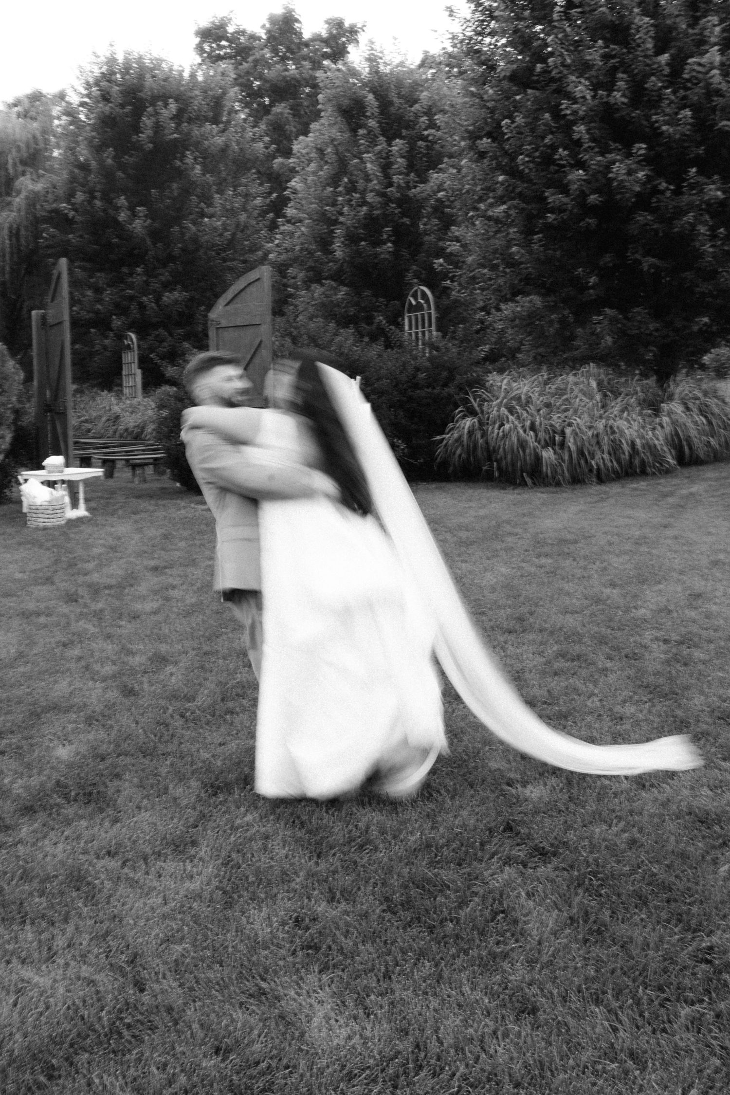 Black and white sequence of dancing and spinning on a grassy lawn at sunset.